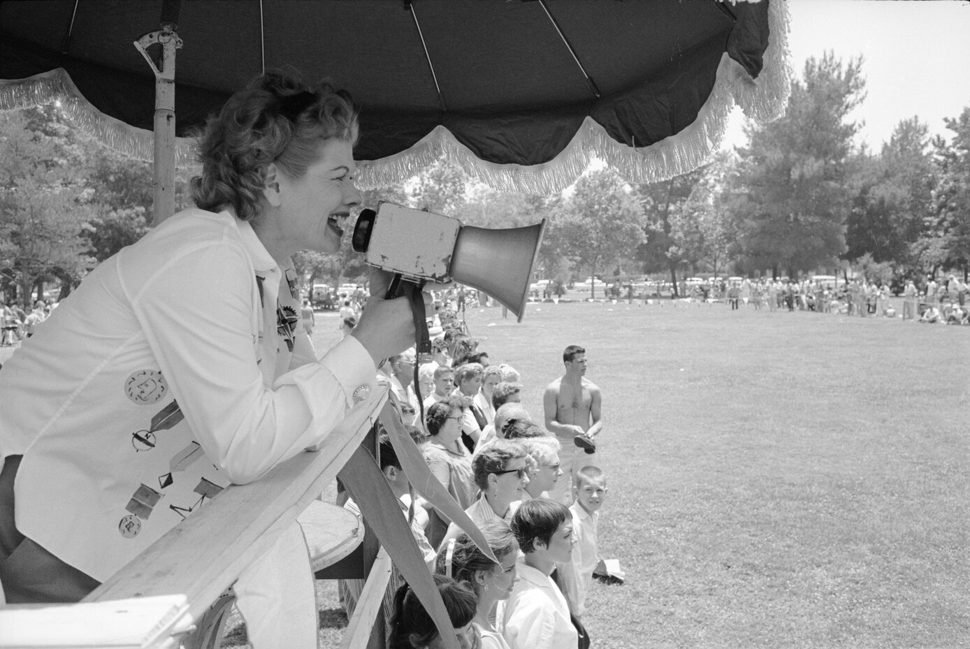 Lucy Arnaz yelling at a crowd with a megaphone during an employee picnic