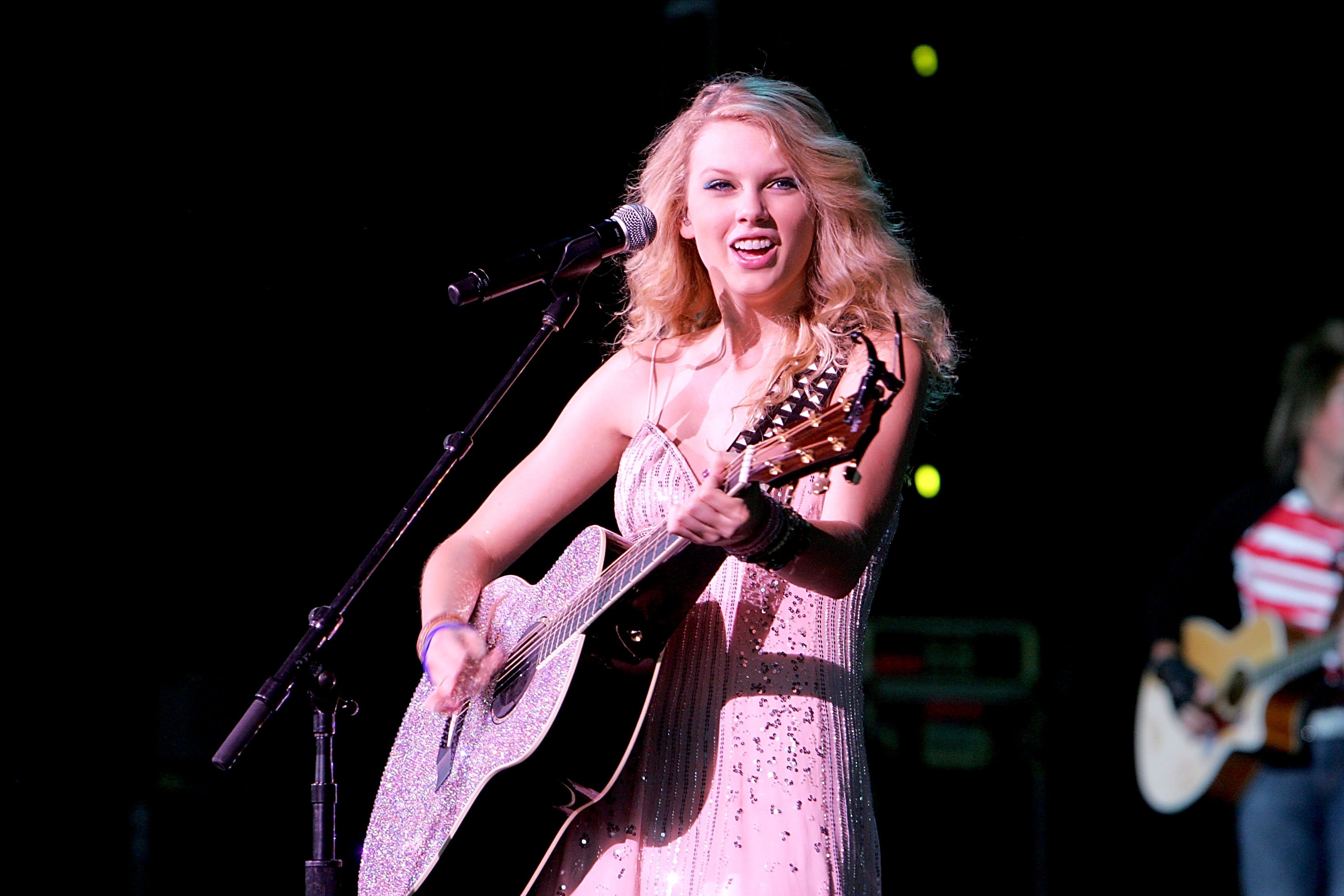 Taylor Swift playing a guitar