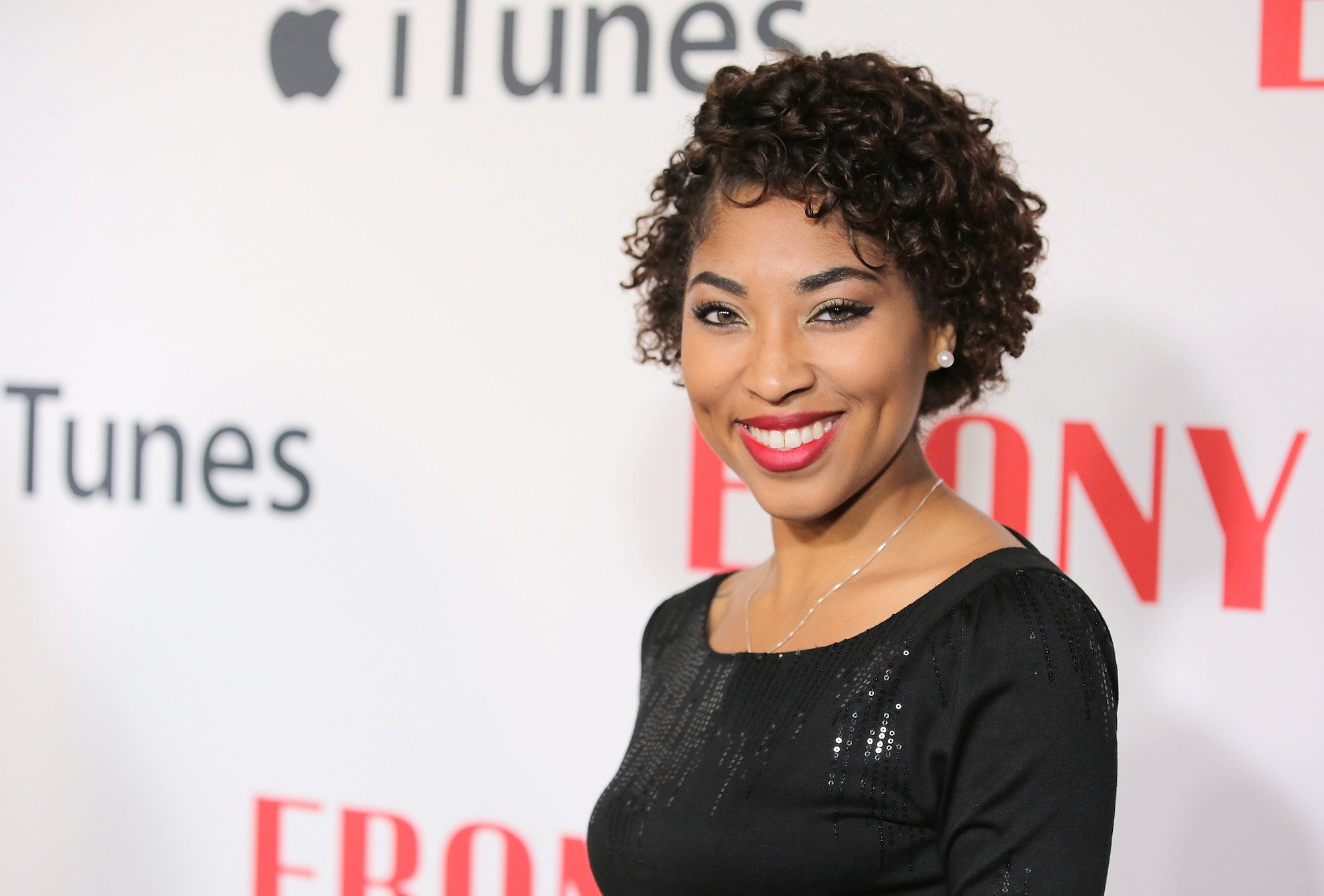 Adriyan Rae smiling in front of a white background