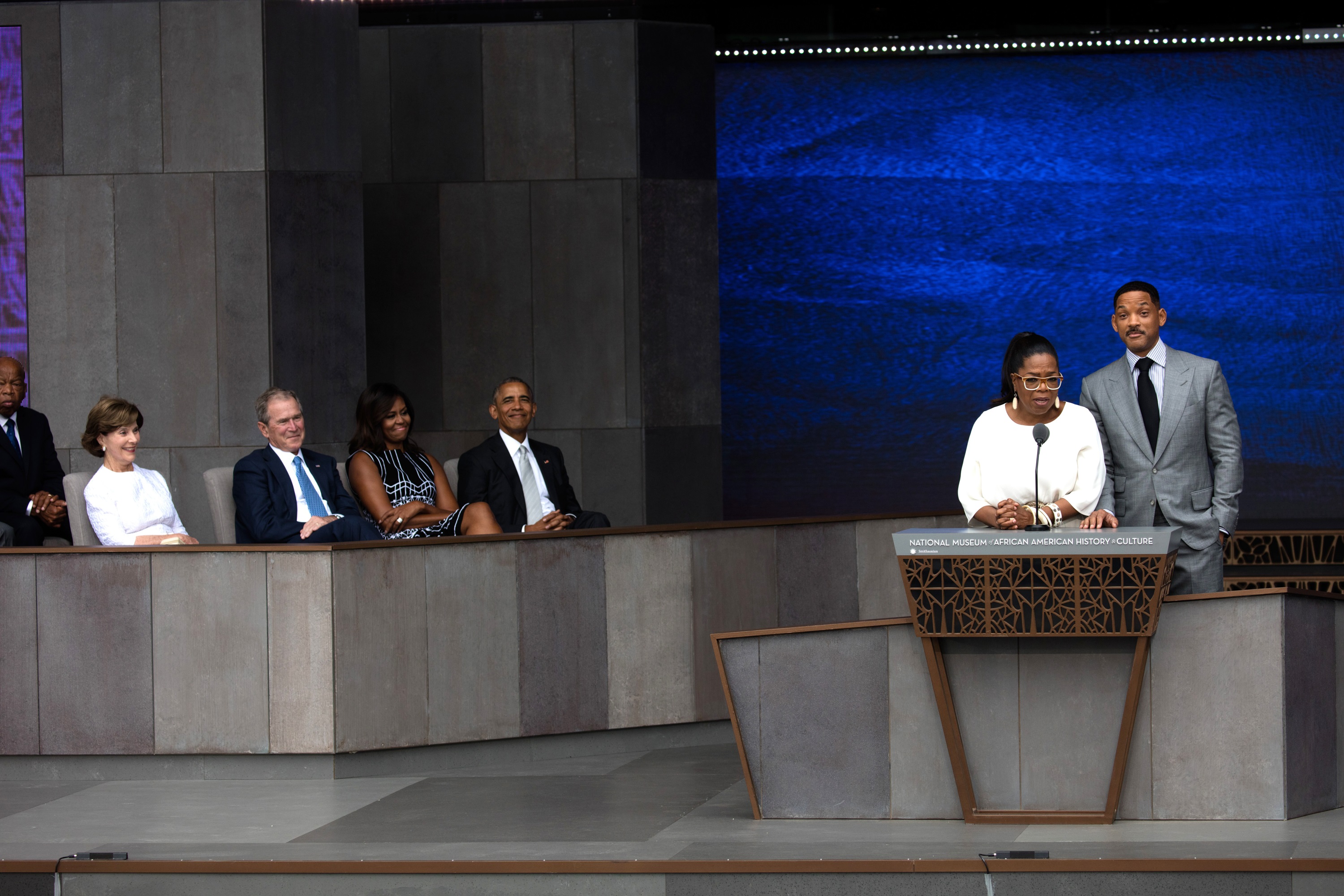Oprah Winfrey and Will Smith present while John Lewis, former First Lady Laura Bush, former President George W Bush, First Lady Michelle Obama, and President Barack Obama listen to their presentation