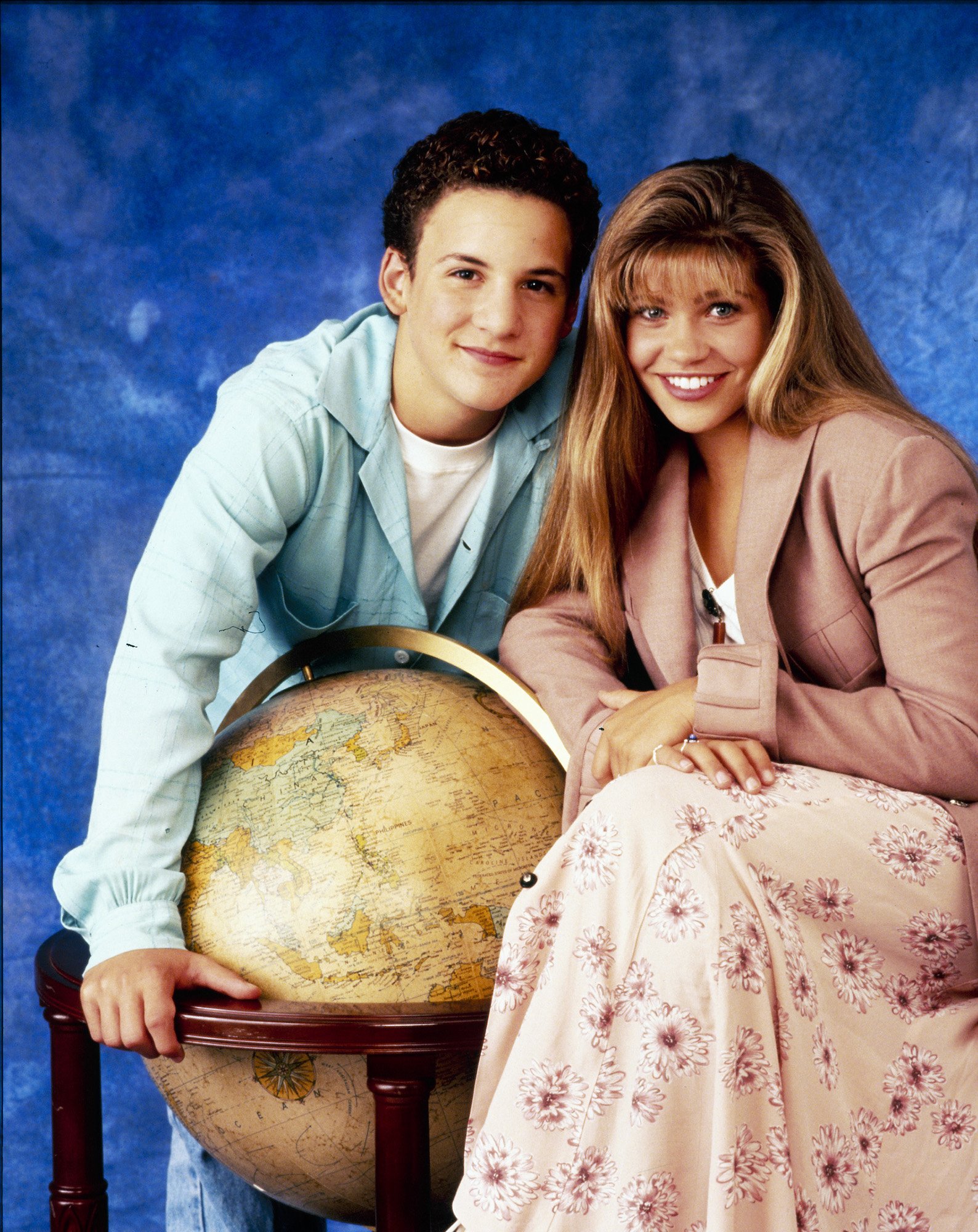 (L-R) Ben Savage as Corey Matthews and Danielle Fishel as Topanga Lawrence, standing near a globe