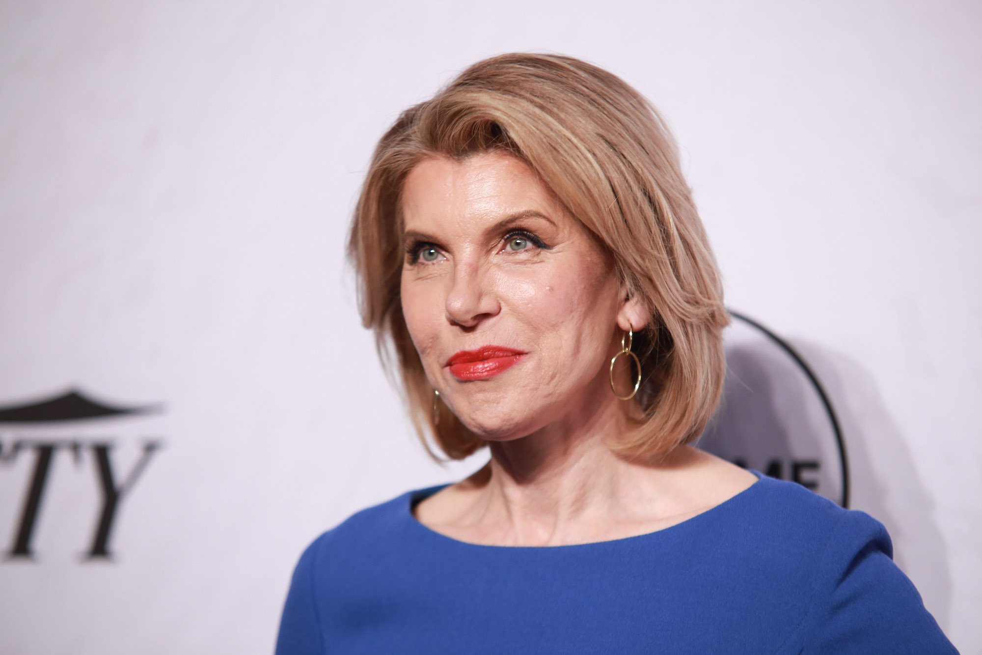 Christine Baranski smiling in front of a white background