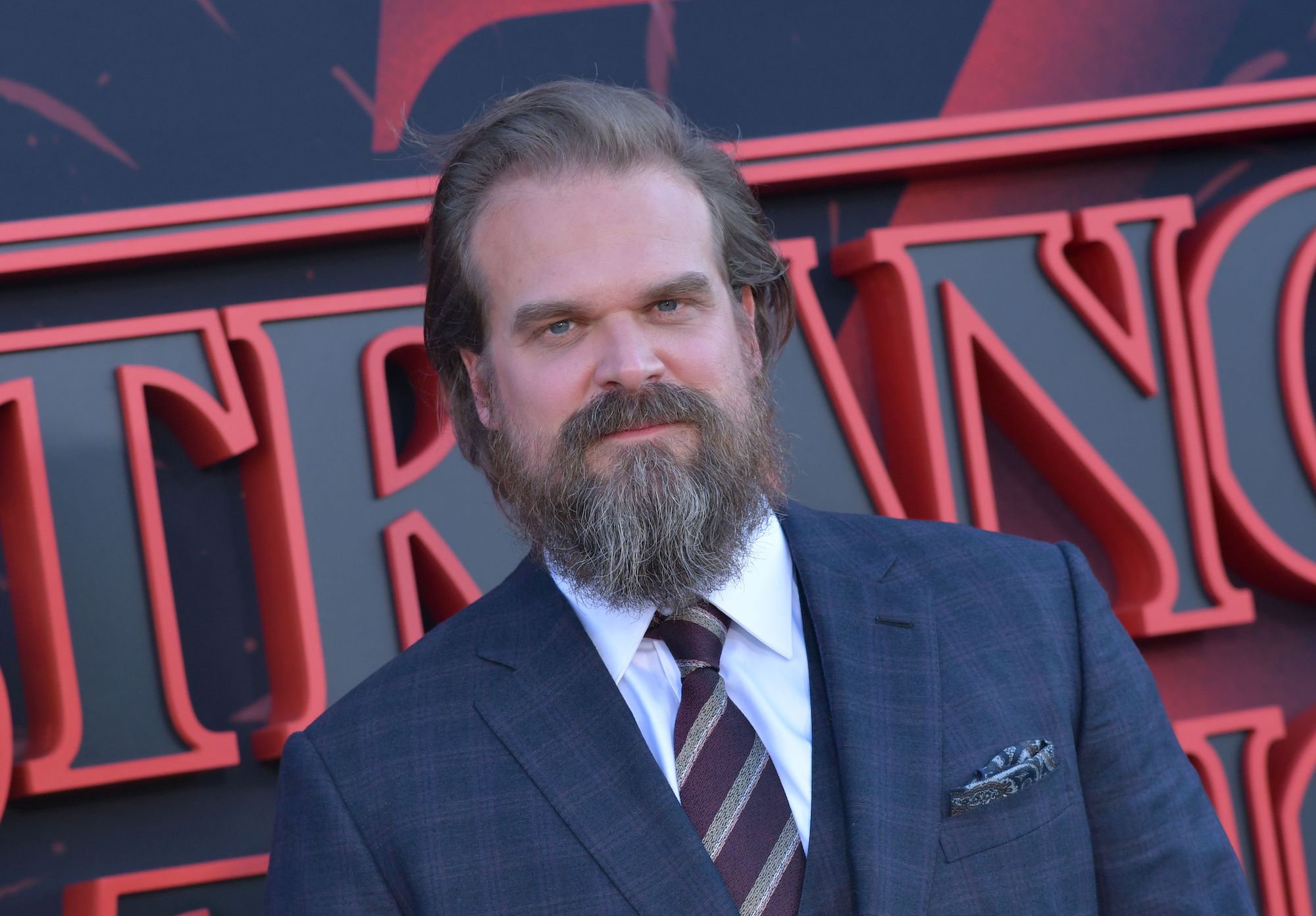David Harbour smiling slightly at the camera