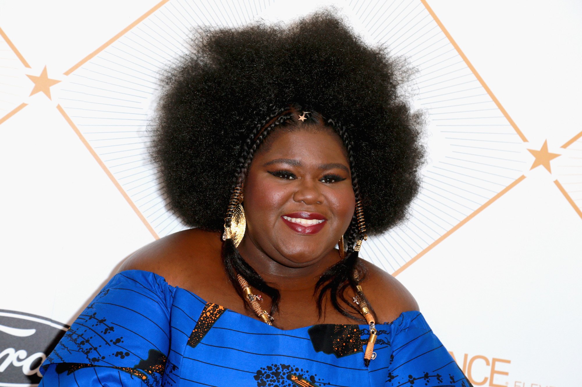 Gabourey Sidibe smiling in front of a white background