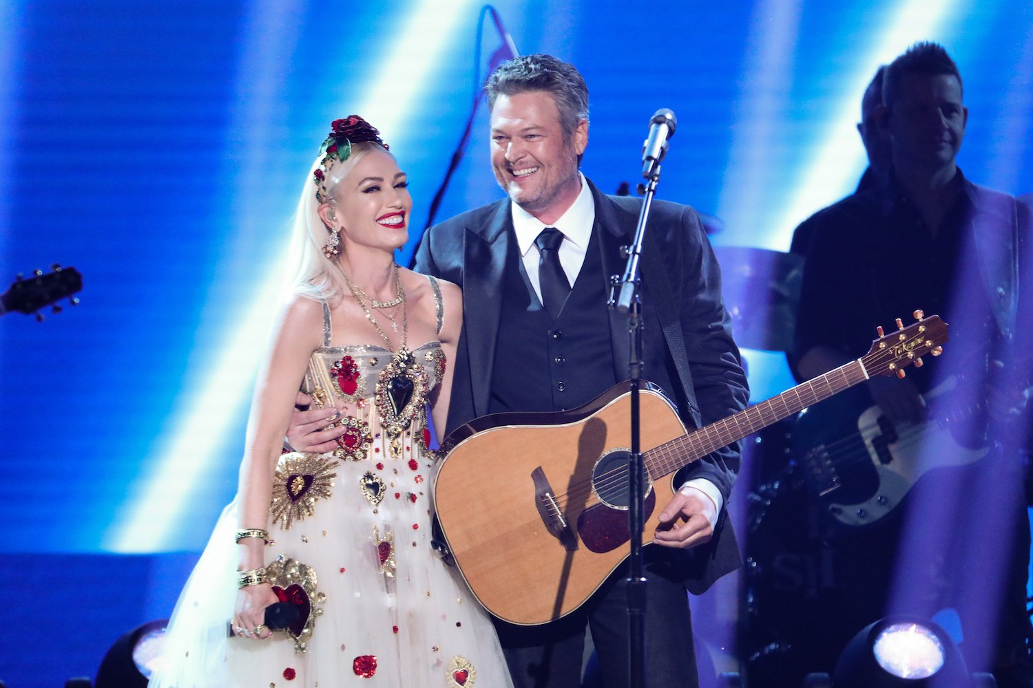 Gwen Stefani and Blake Shelton embracing,smiling on stage