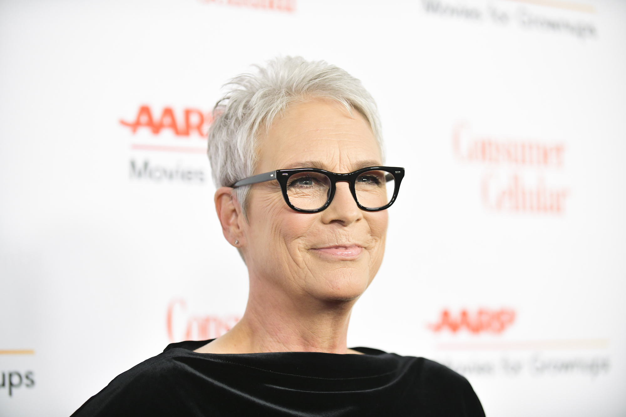 Jamie Lee Curtis smiling in front of a white background
