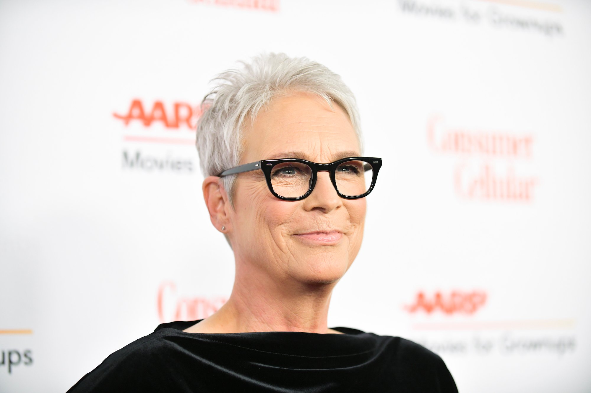 Jamie Lee Curtis smiling in front of a white background