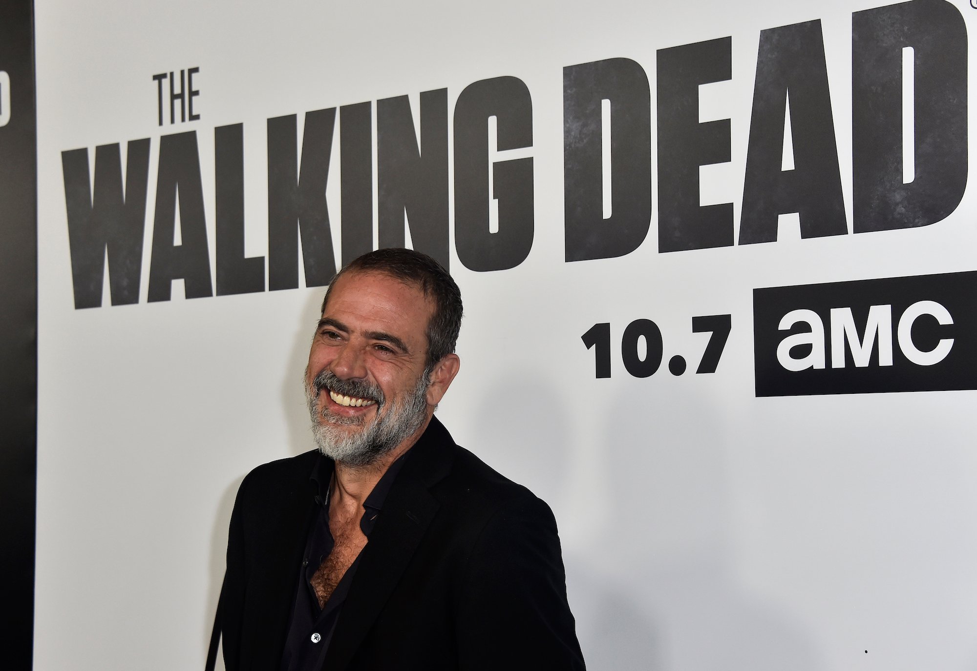 Jeffery Dean Morgan smiling in front of a 'Walking Dead' branded background