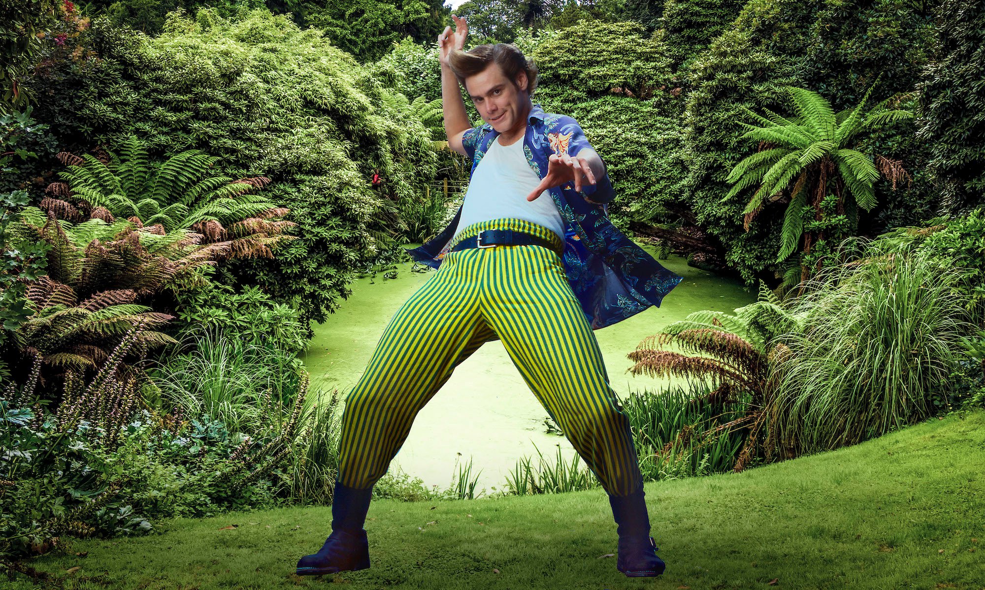 Jim Carrey as Ace Ventura posing for a photo in front of a pond and greenery