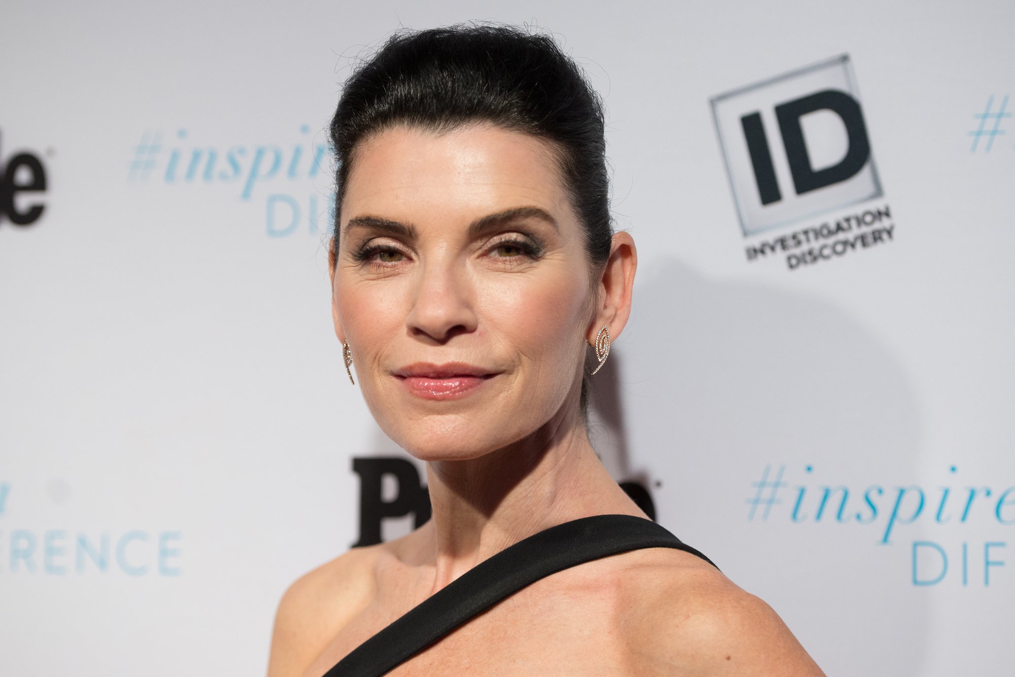 Julianna Margulies smiling in front of a white backdrop