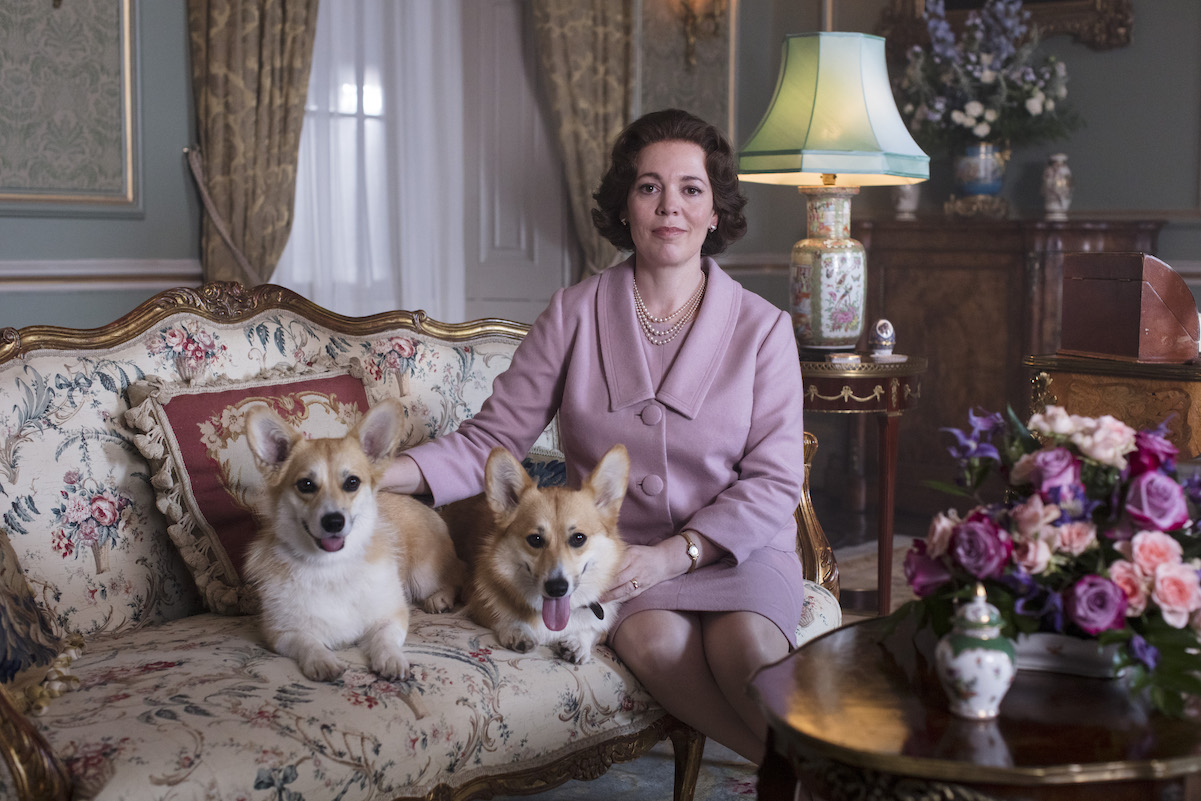 Olivia Colman as Queen Elizabeth II posing with dogs in 'The Crown' Season 3 Episode 2 