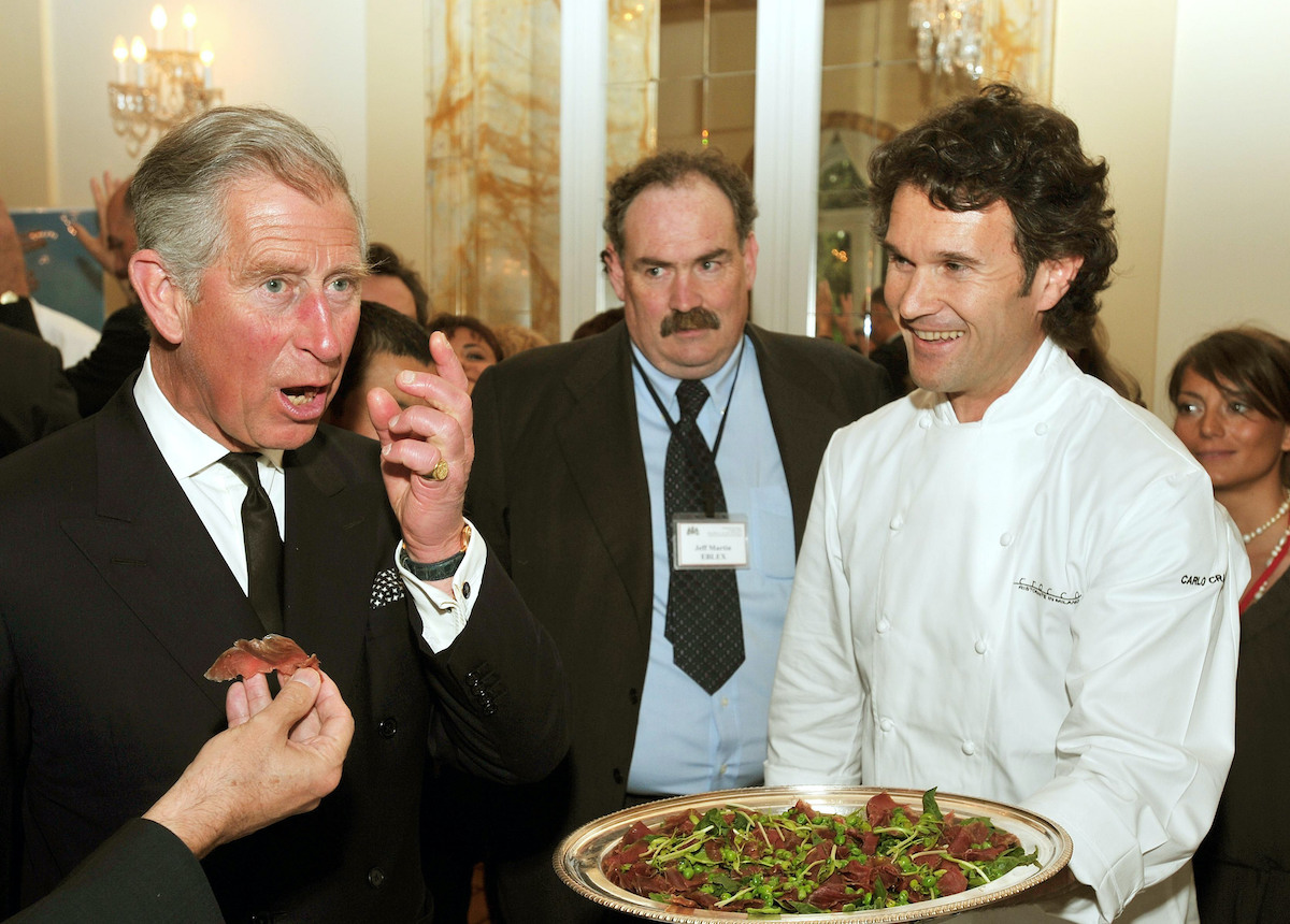 Prince Charles, Prince of Wales (L) tries some beef prepared by chef Carlo Cracco (R) during an organic food reception at the British Ambassador's residence on April 27, 2009 in Rome, Italy. After touring the marble rooms and viewing Raphael tapestry and paintings at the Vatican, the Prince of Wales and Duchess of Cornwall were ushered to a Slow Food reception at the British Embassy where they were given a taste of Anglo-Italian cuisine, including beef from their own Highgrove Estate farm