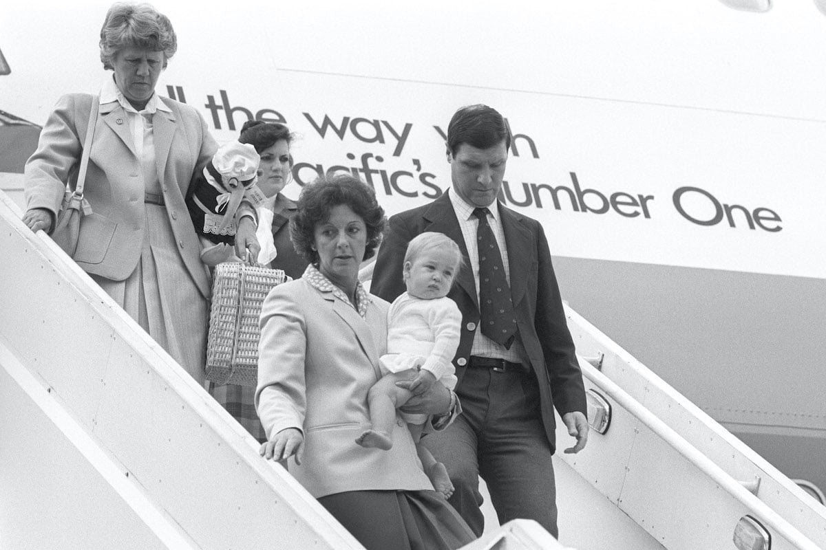 Prince William of Wales in the arms of his nanny Barbara Barnes arrives at Gatwick Airport after a 27-hour, 13,000-mile journey from New Zealand in a Boeing 747. The 10-month old Prince had just ended a six-week holiday in Australia and New Zealand where his parents, the Prince and Princess of Wales, had enjoyed a tour of the two countries. They were now on their way to a 10-day holiday in the Bahamas 