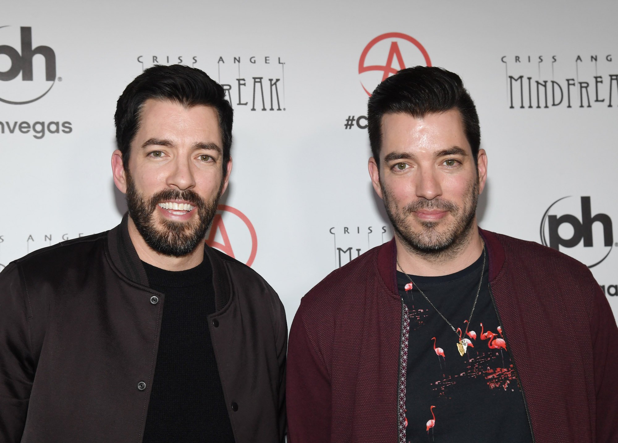 (L-R) Drew Scott and Jonathan Scott smiling in front of a white background