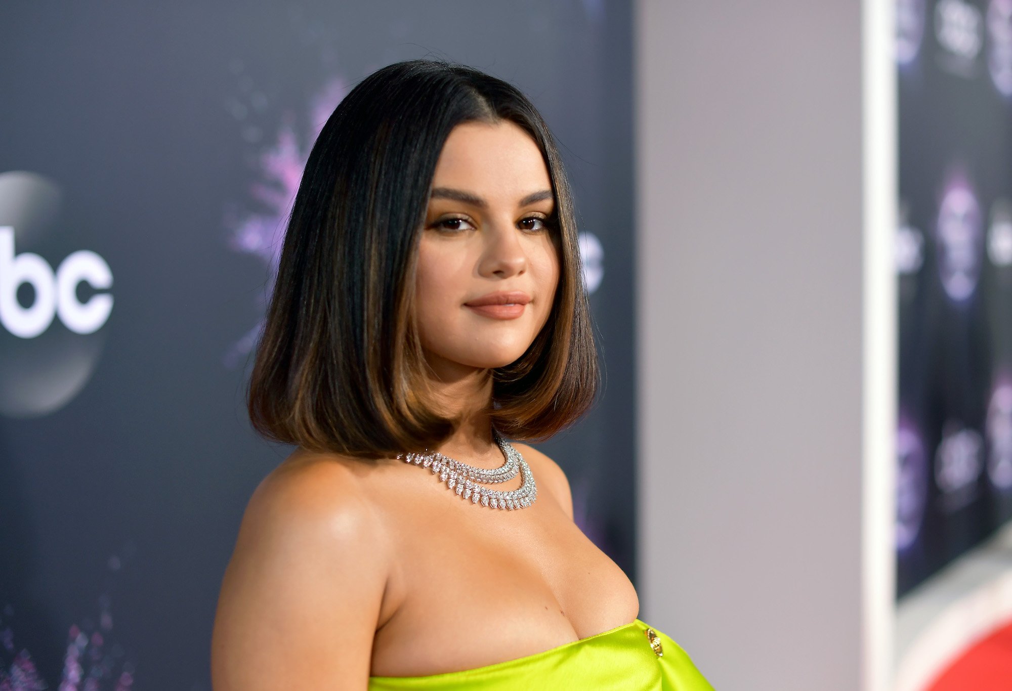 Selena Gomez smiling in front of a blurred background