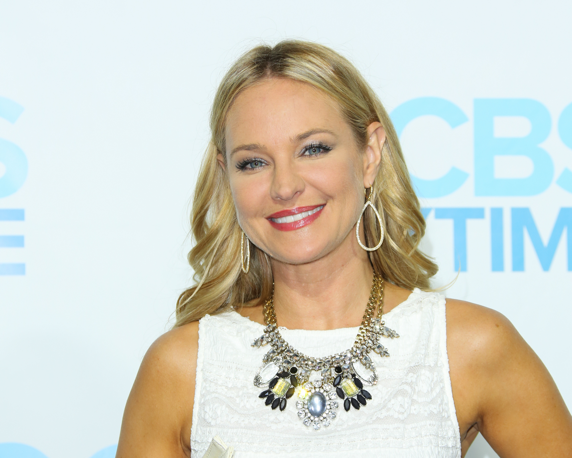 Sharon Case smiling in front of a white background