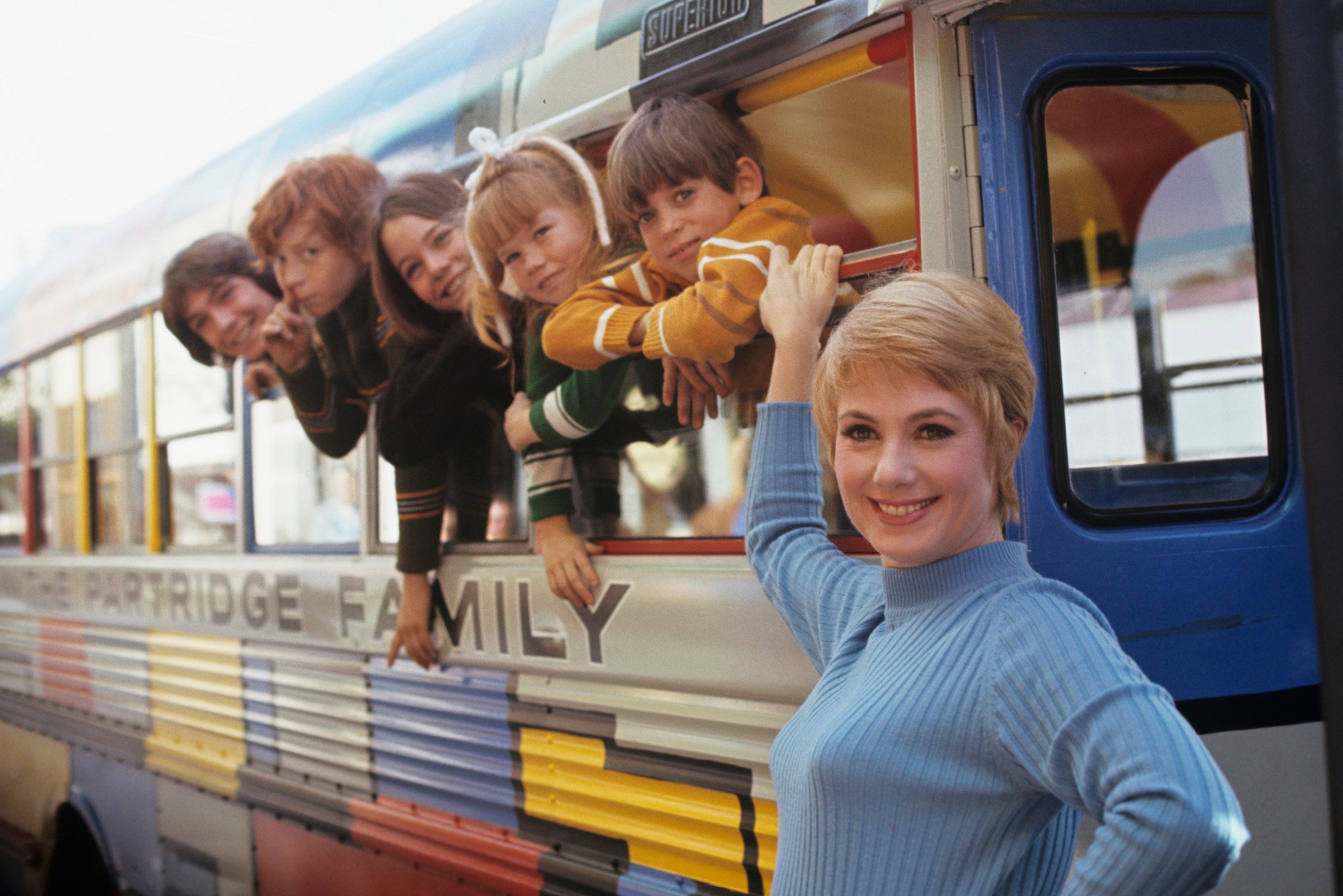 (L-R) David Cassidy, Danny Bonaduce, Susan Dey, Suzanne Crough, Jeremy Gelbwaks, Shirley Jones smiling with 'The Partridge Family's' bus