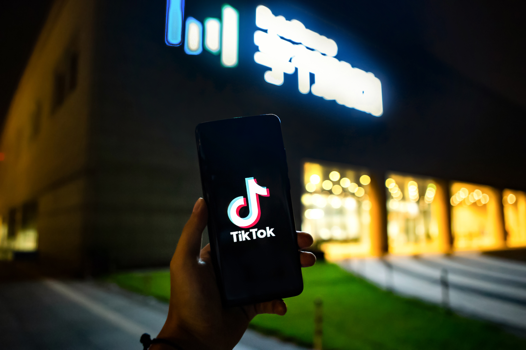 A mobile phone screen shows video app TikTok in front of the headquarters of digital media company ByteDance