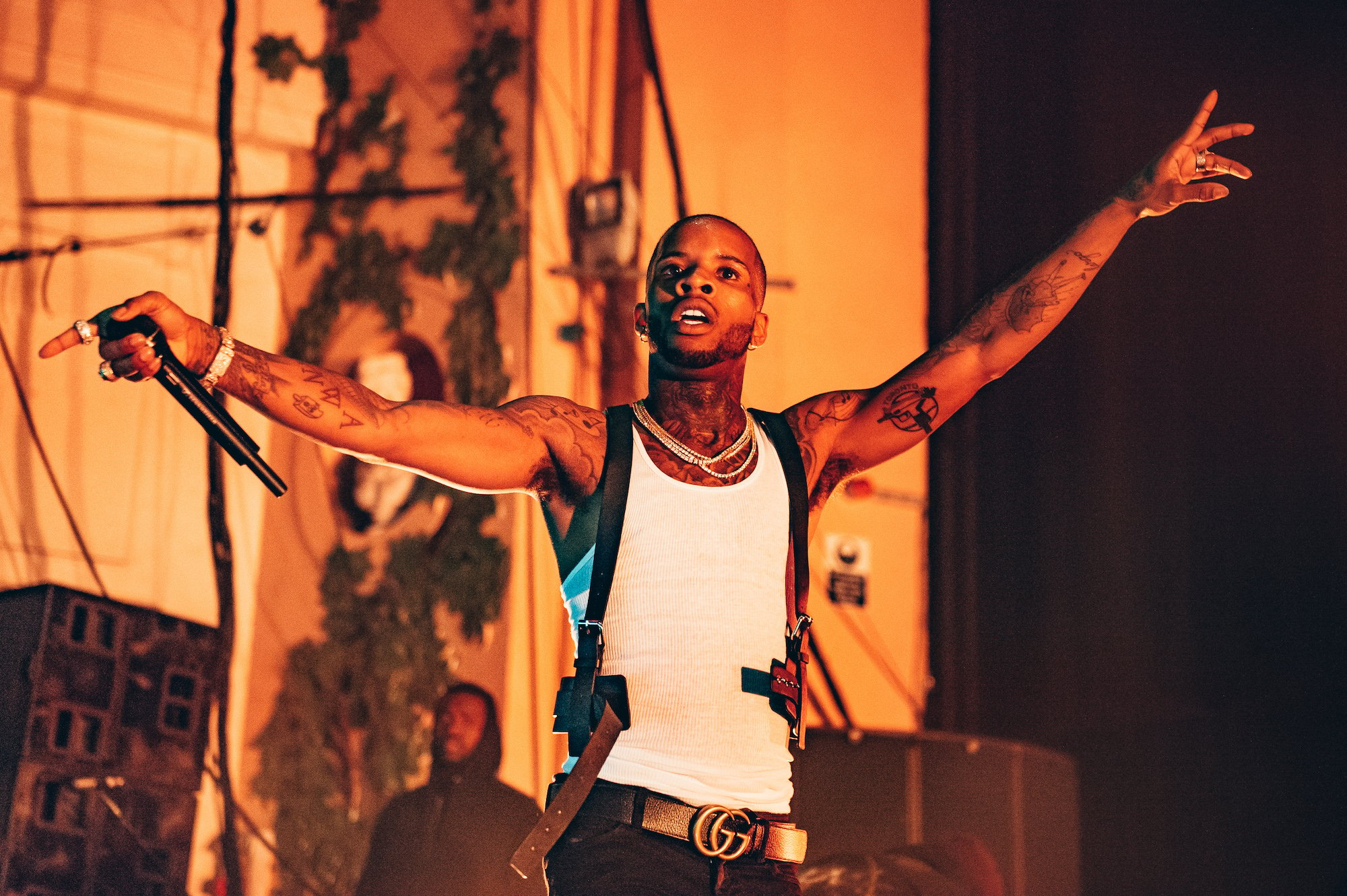 Tory Lanez on stage with his arms outstretched