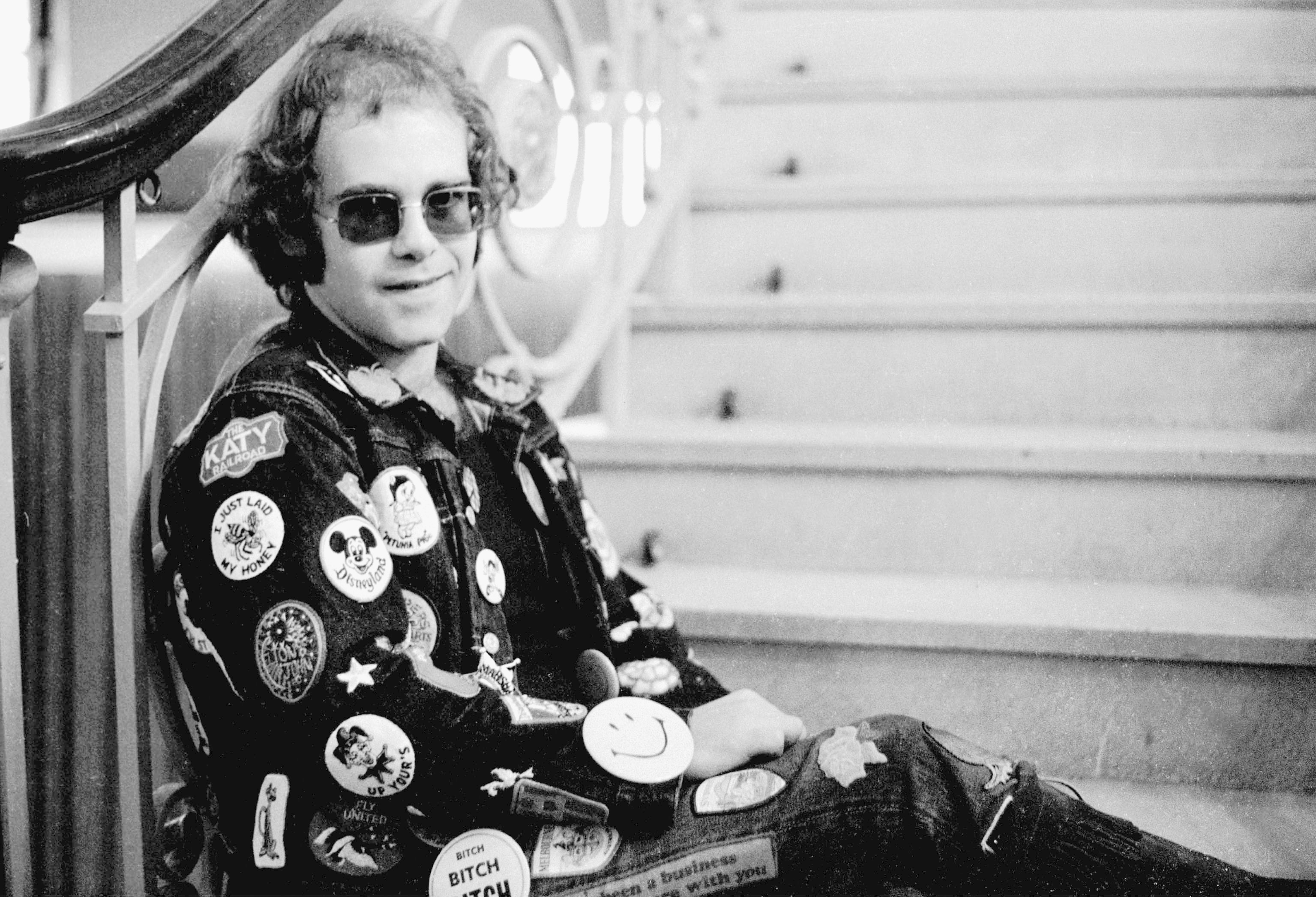 Elton John sitting on stairs