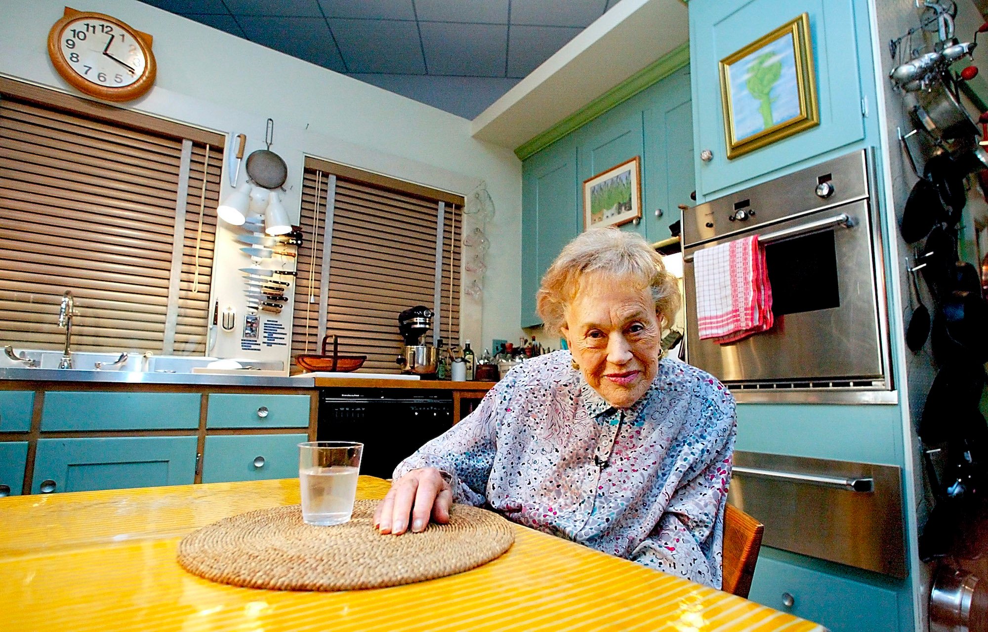 Julia Child sits in her kitchen