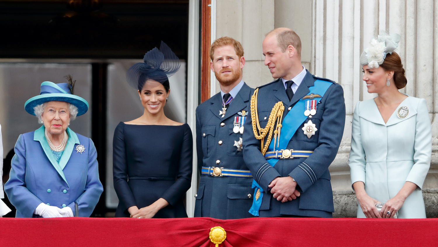 Queen Elizabeth II, Meghan Markle, Prince Harry, Prince William, and Kate Middleton watch a flypast to mark the centenary of the Royal Air Force from the balcony of Buckingham Palace