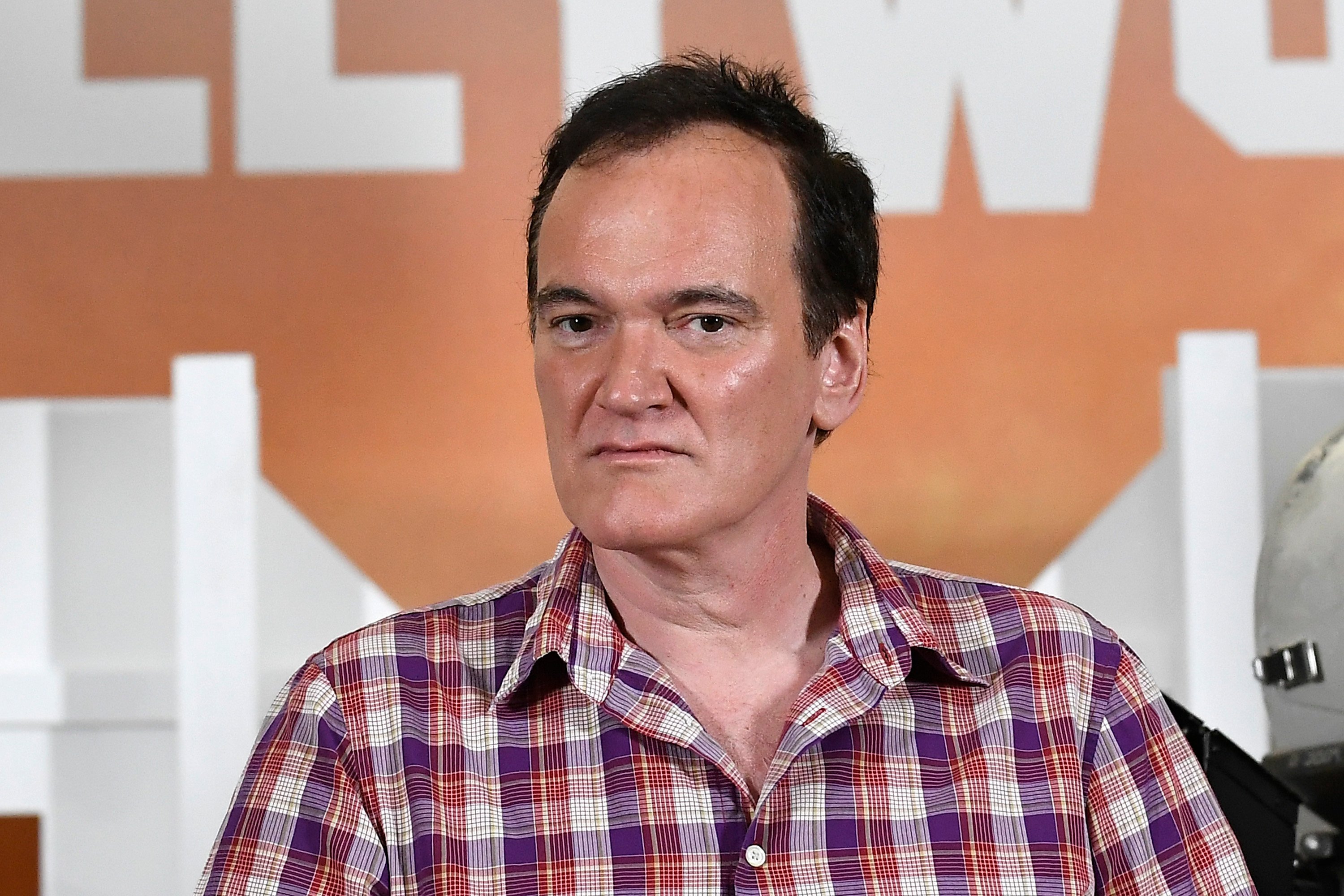 Quentin Tarantino in front of a poster