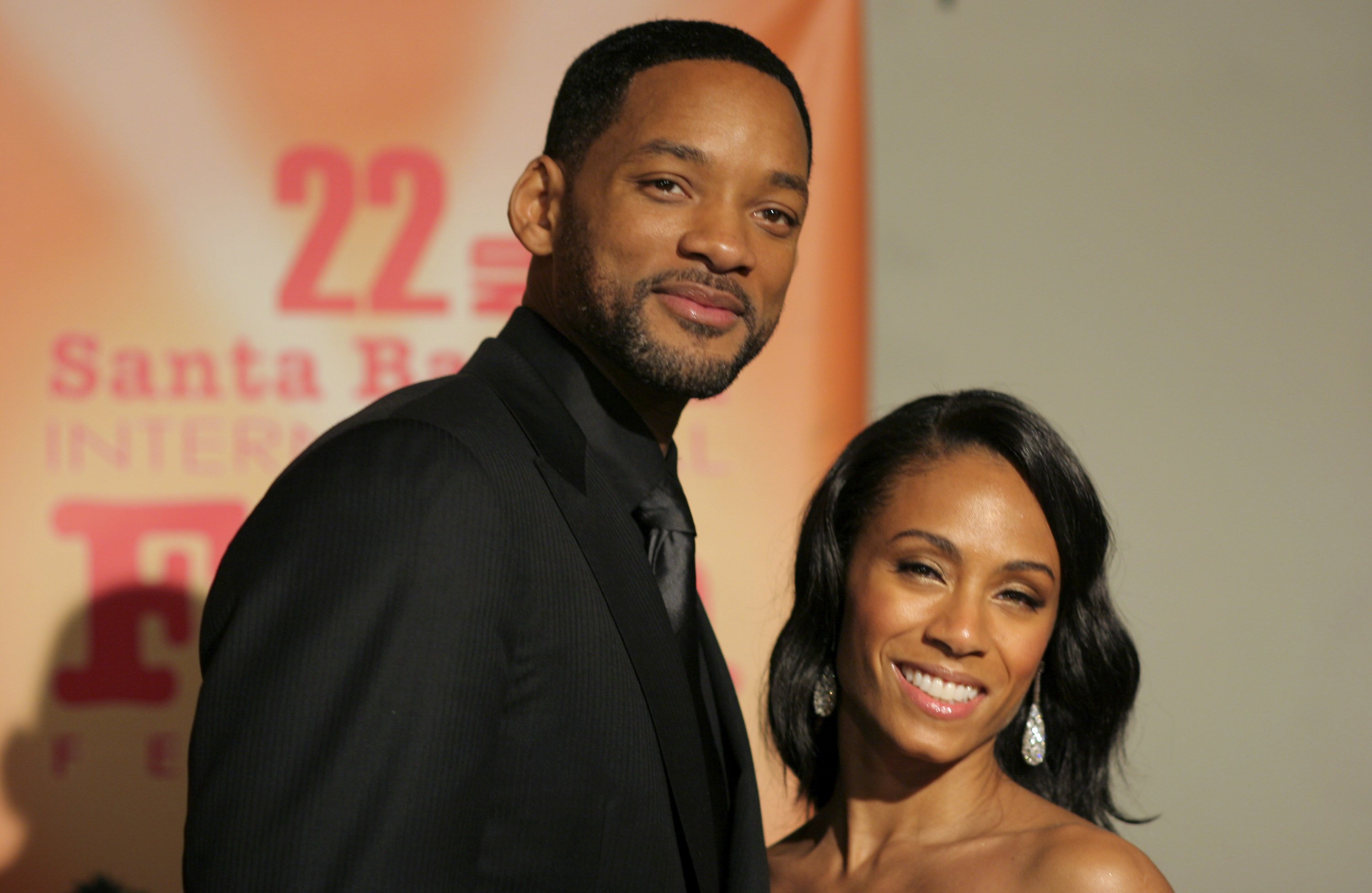 Will Smith and Jada Pinkett Smith in front of a poster