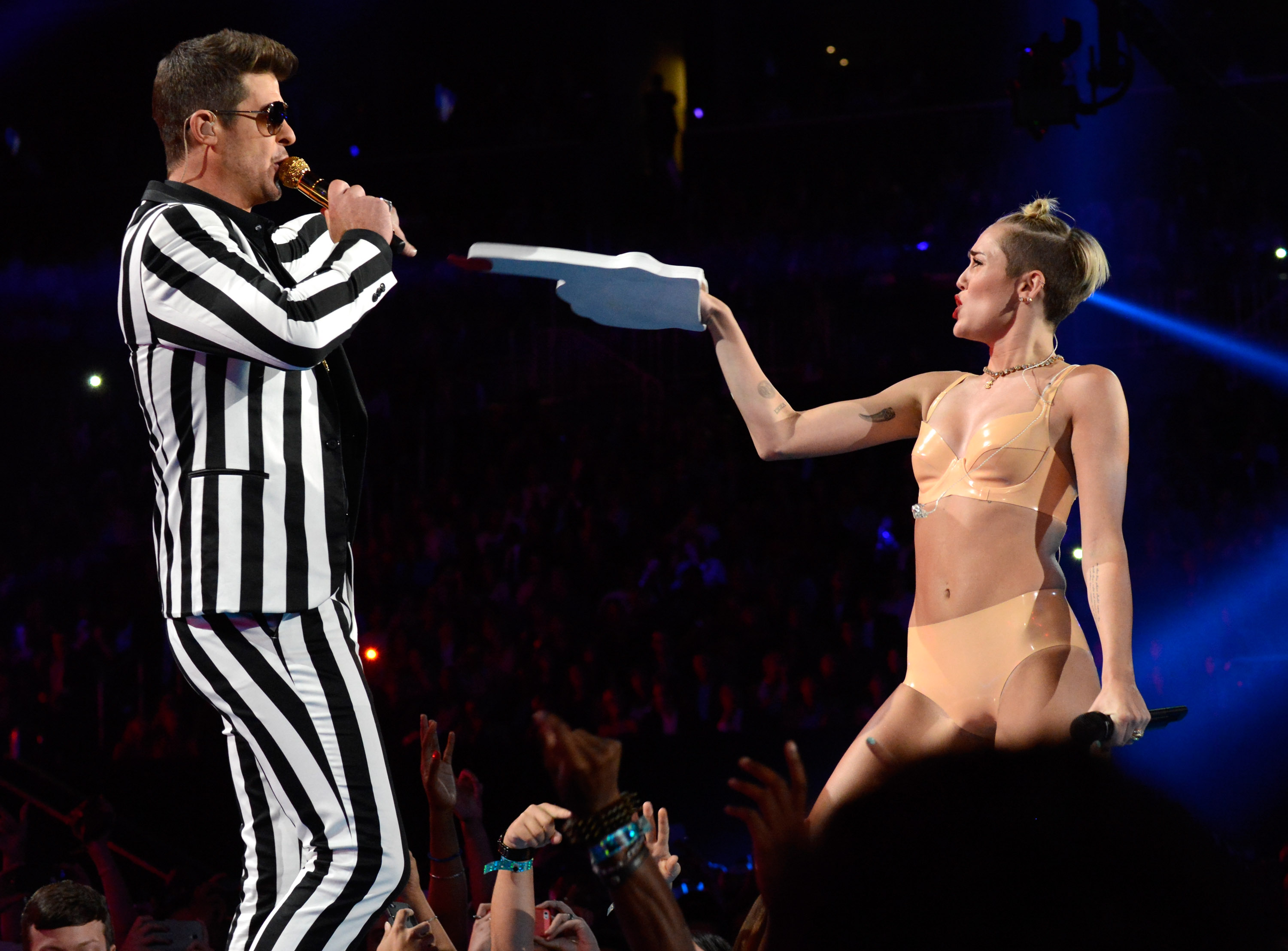 Miley Cyrus pointing a foam finger at Robin Thicke