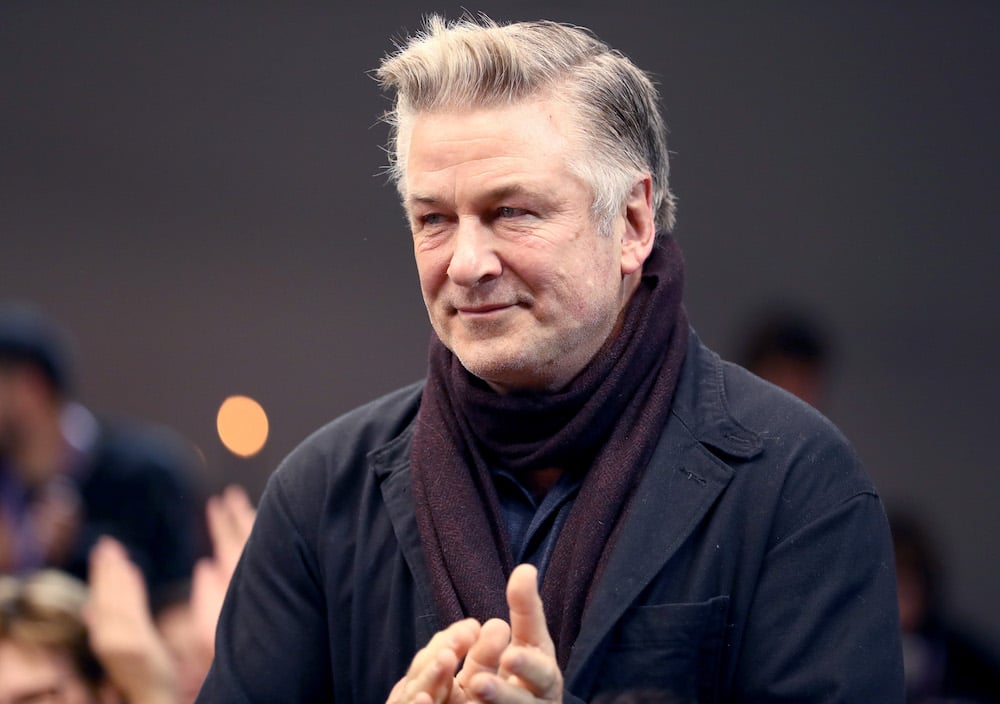 Alec Baldwin looking to the left in front of a blurred background