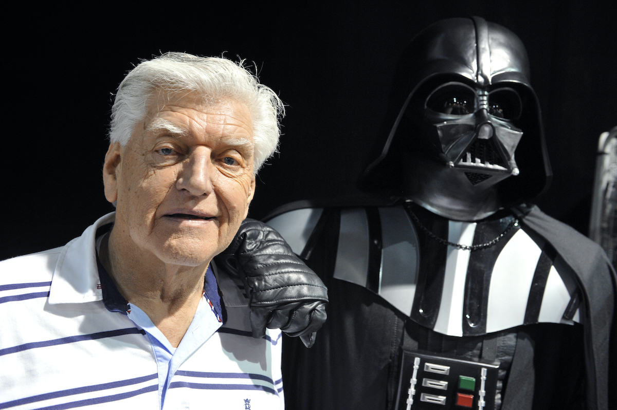 English actor David Prowse poses with a fan dressed up in a Darth Vader costume during a Star Wars convention on April 27, 2013 | Thierry Zoccolan/AFP via Getty Images