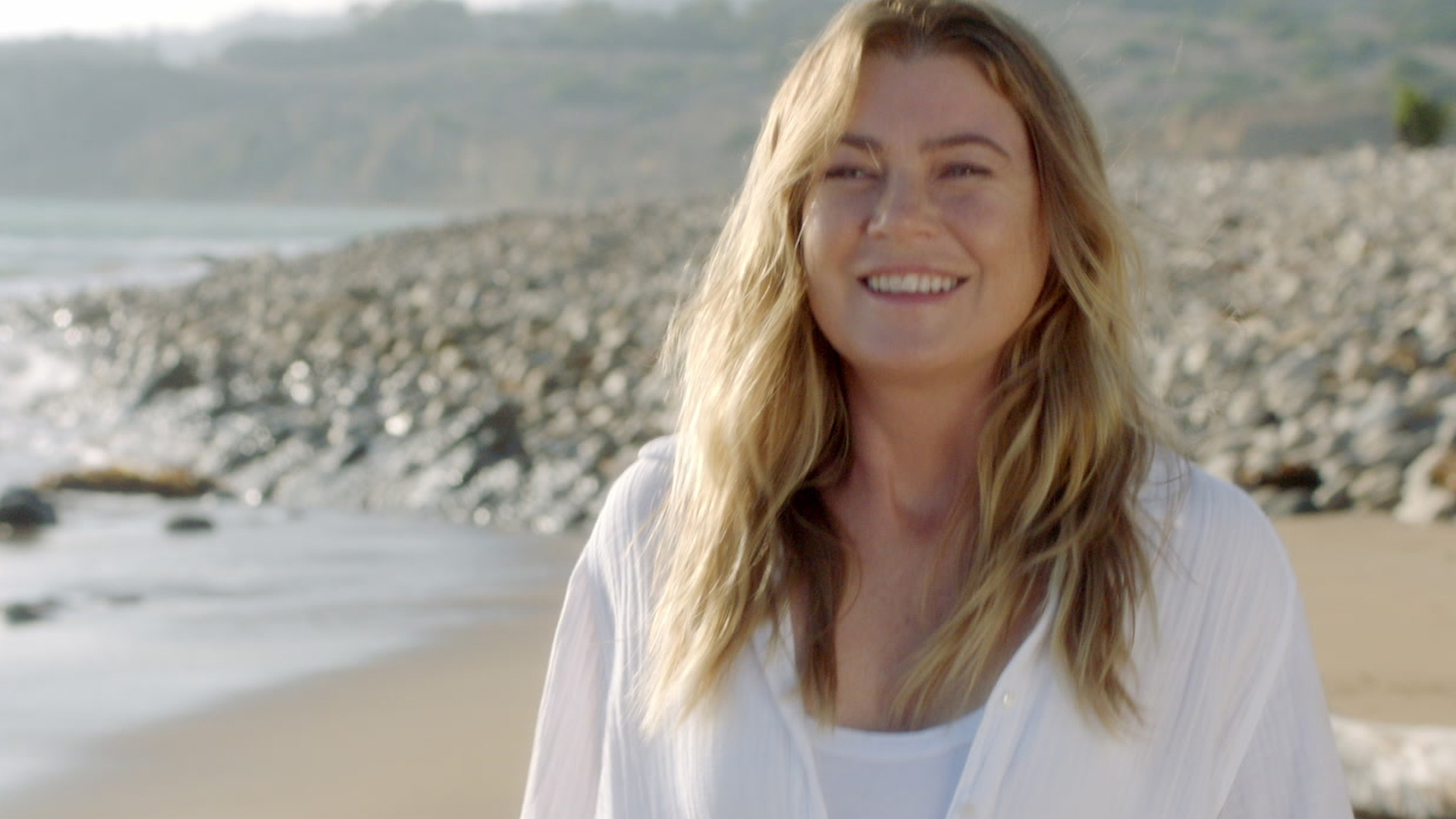Ellen Pompeo as Meredith Grey on 'Grey's Anatomy' Season 17 Episode 3 on the beach smiling at Derek Shepherd (Patrick Dempsey)