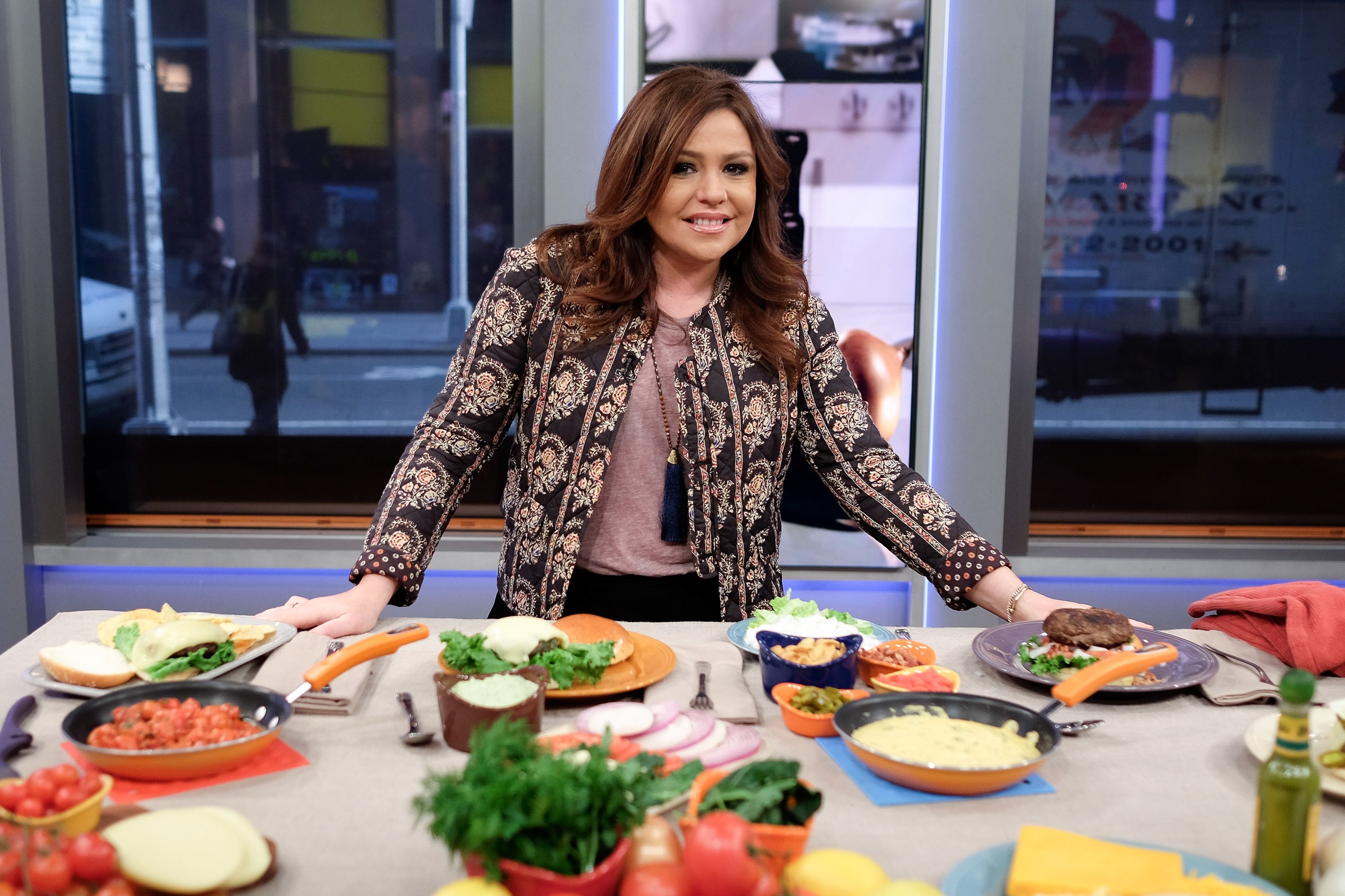 Rachael Ray standing behind table with food ingredients