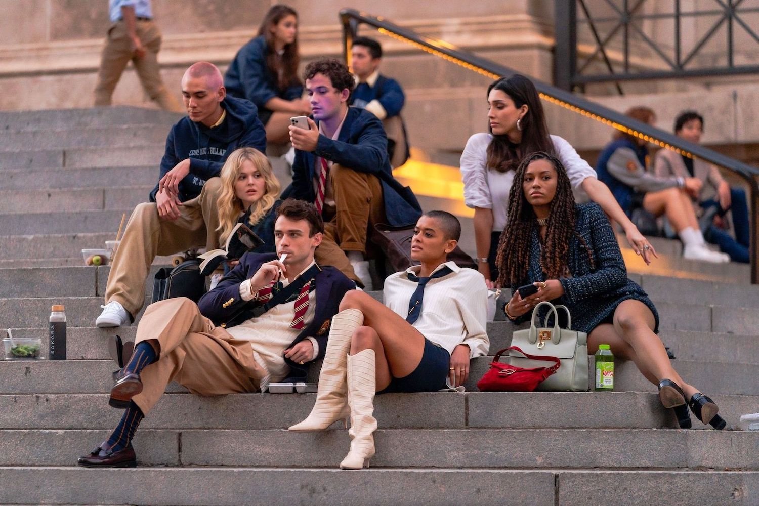 (L-R) Evan Mock, Emily Alyn Lind, Thomas Doherty, Eli Brown, Jordan Alexander, Zion Moreno and Savannah Lee Smith sitting on the steps of the Metropolitan Museum of Art in the Upper East Side of New York, New York