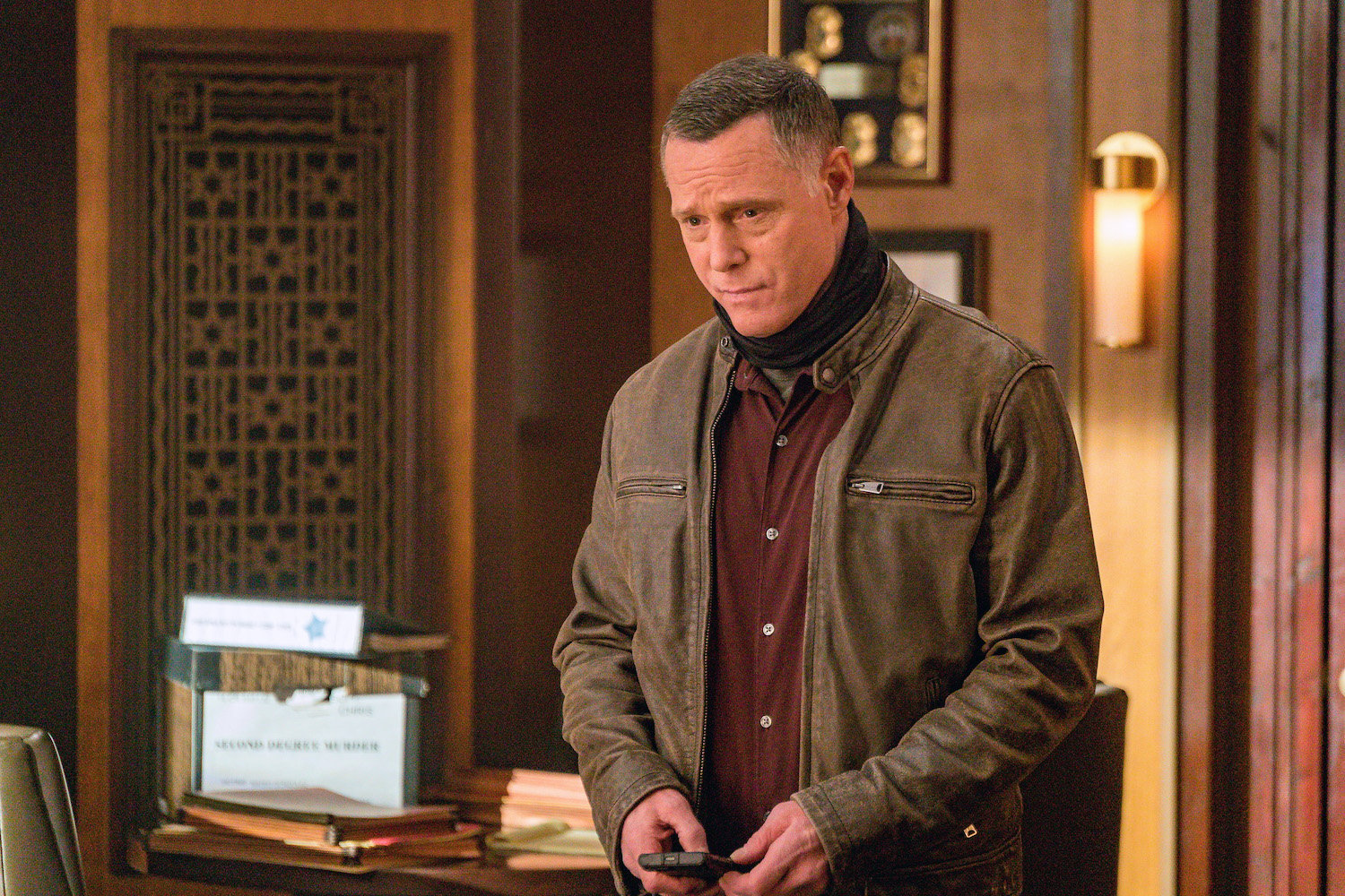 Jason Beghe as Hank Voight wearing a neck gaiter, looking down