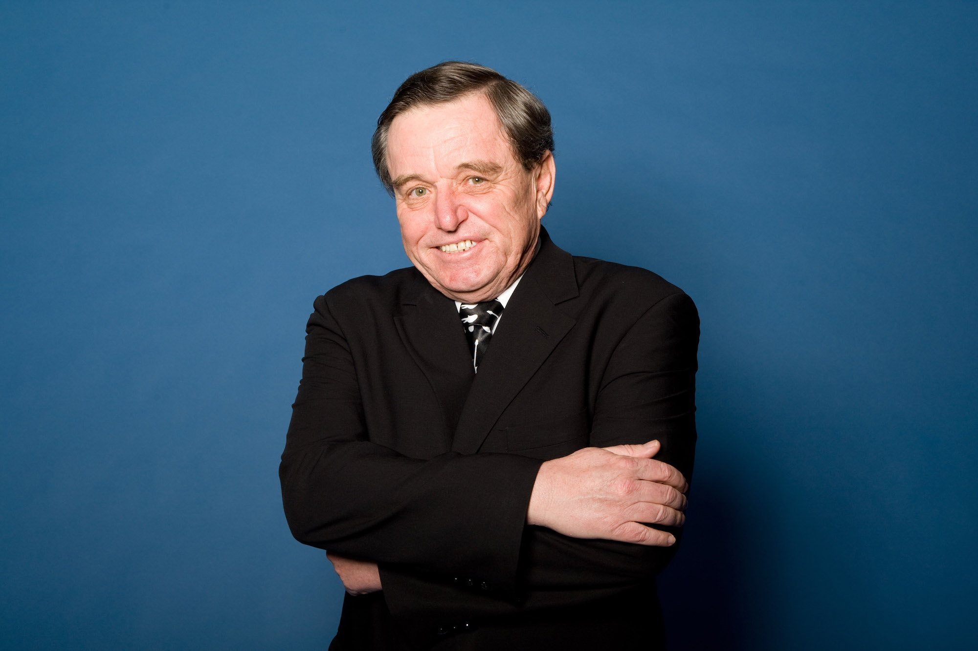 Jerry Mathers smiling in front of a blue background