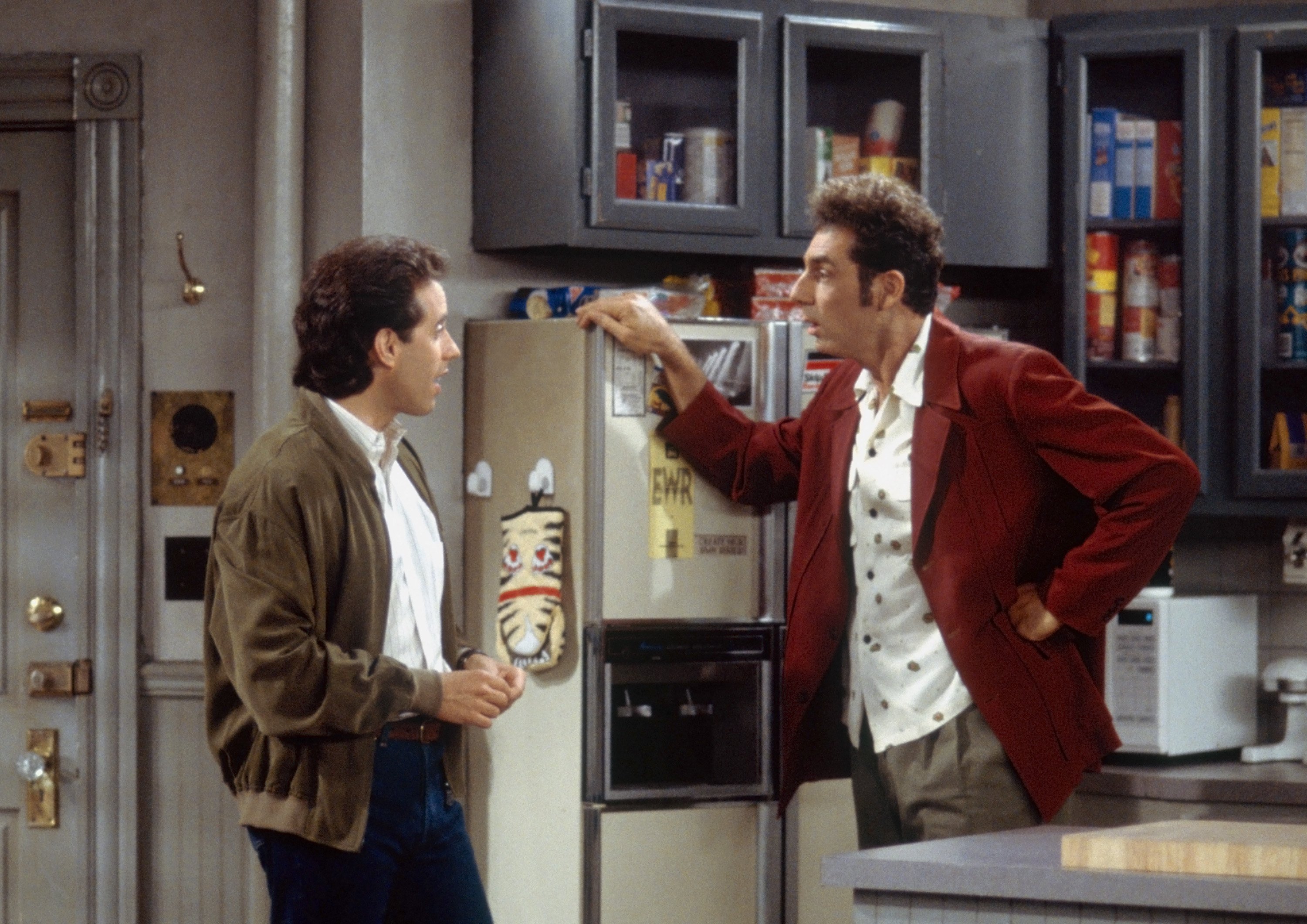 Jerry Seinfeld as Jerry Seinfeld, Michael Richards as Cosmo Kramer stand in Jerry's kitchen
