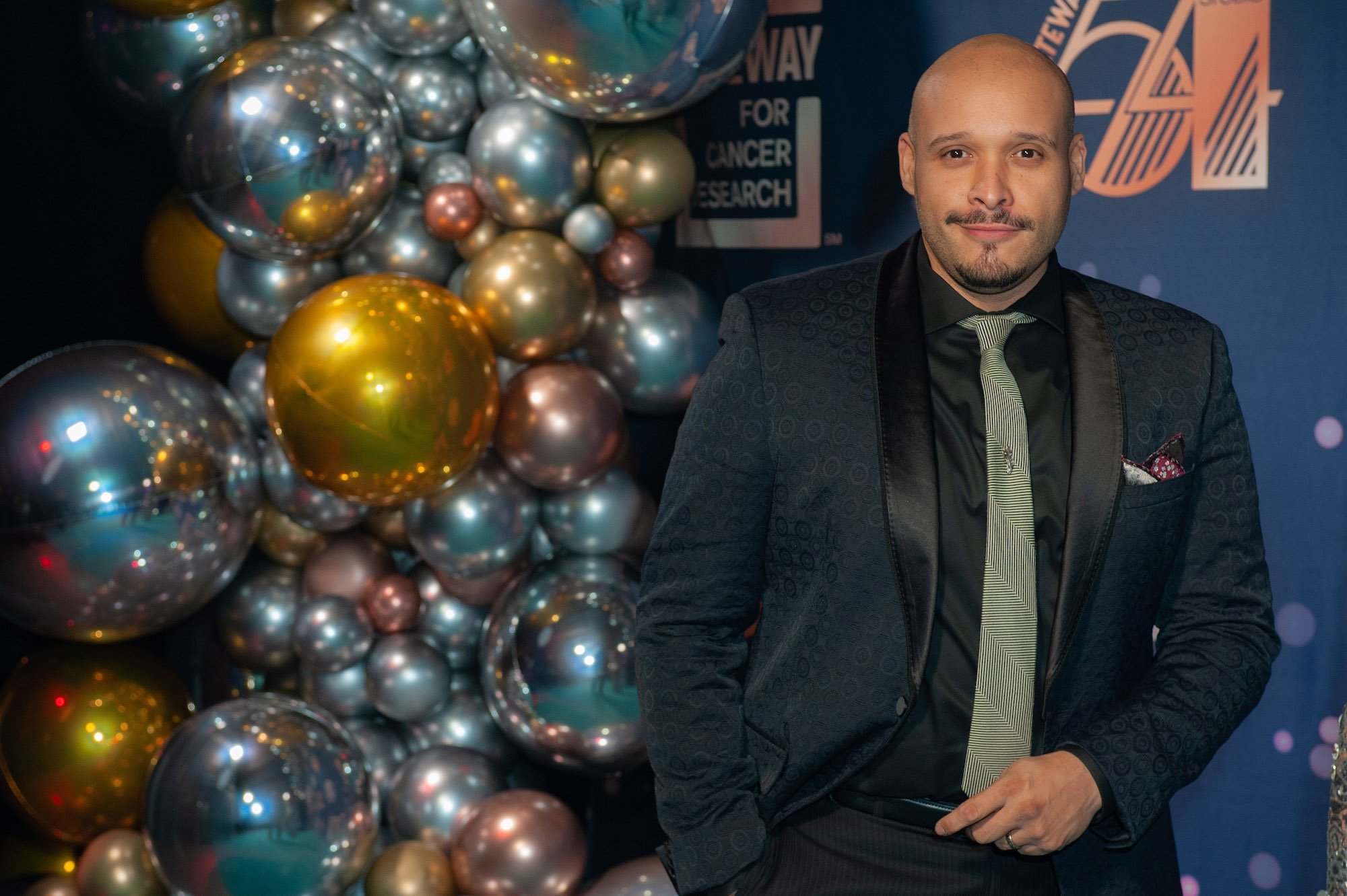 Joe Minoso smiling in front of balloons