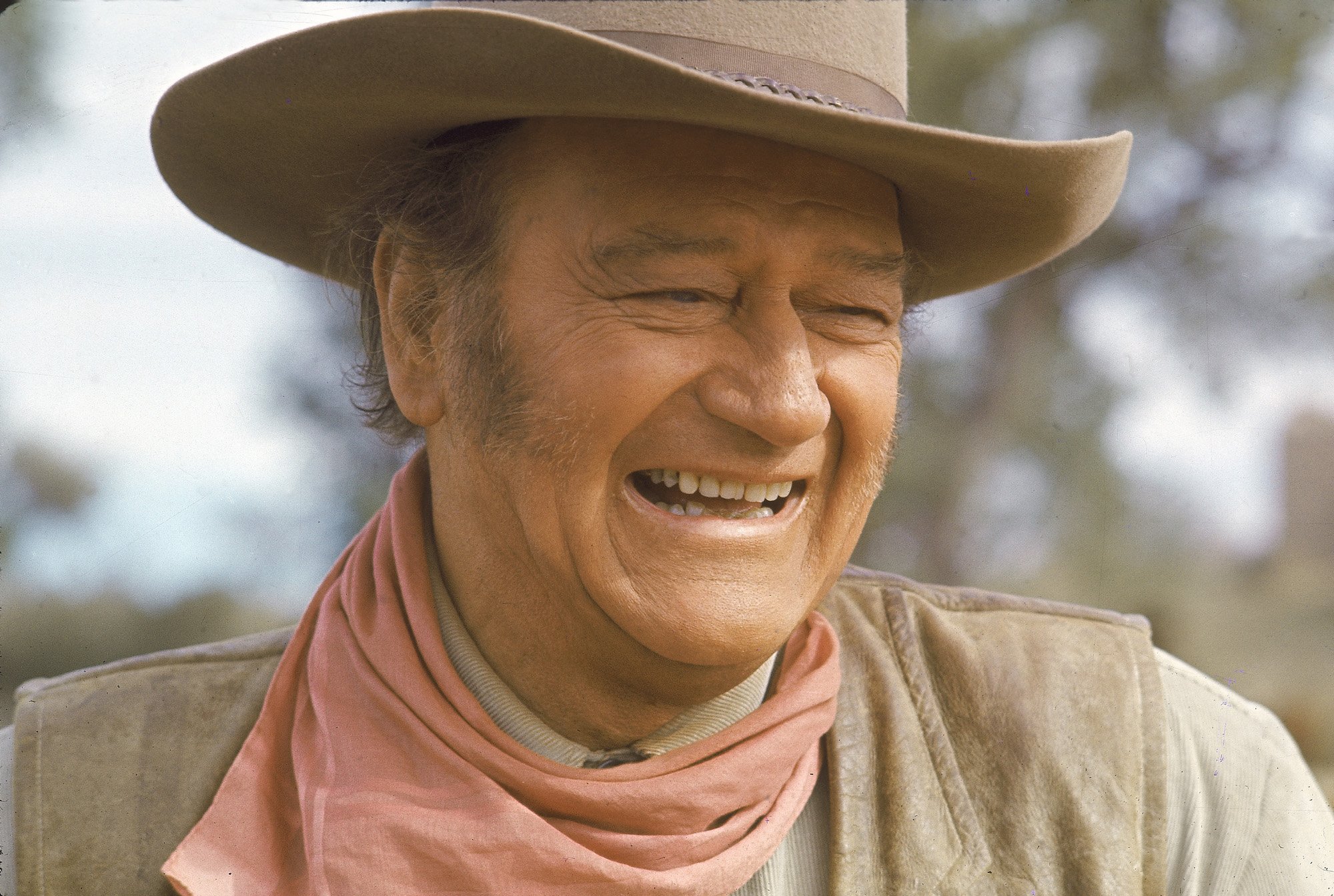 John Wayne in costume, laughing, while filming 'The Undefeated'