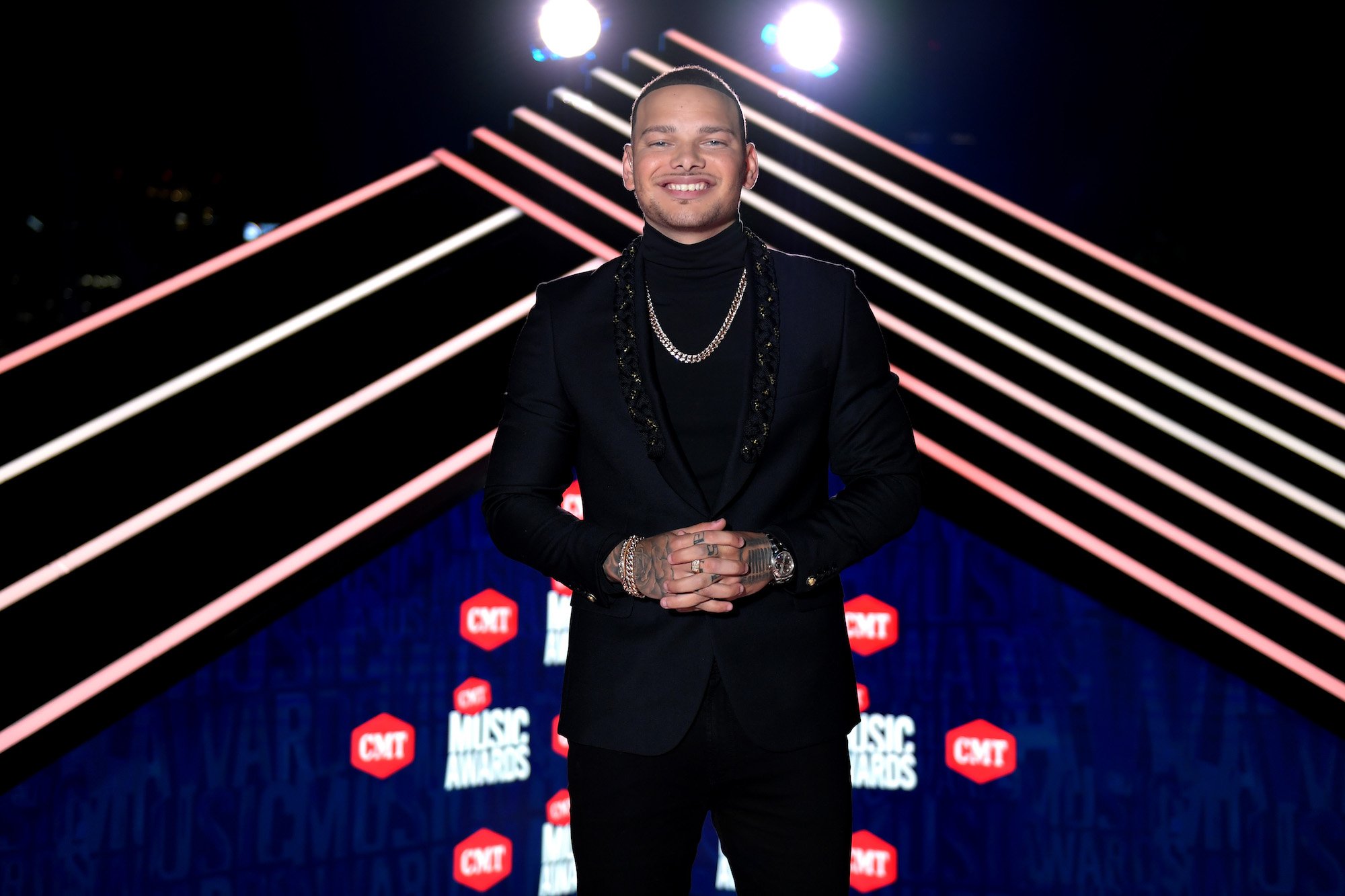 Kane Brown smiling in front of stage lights