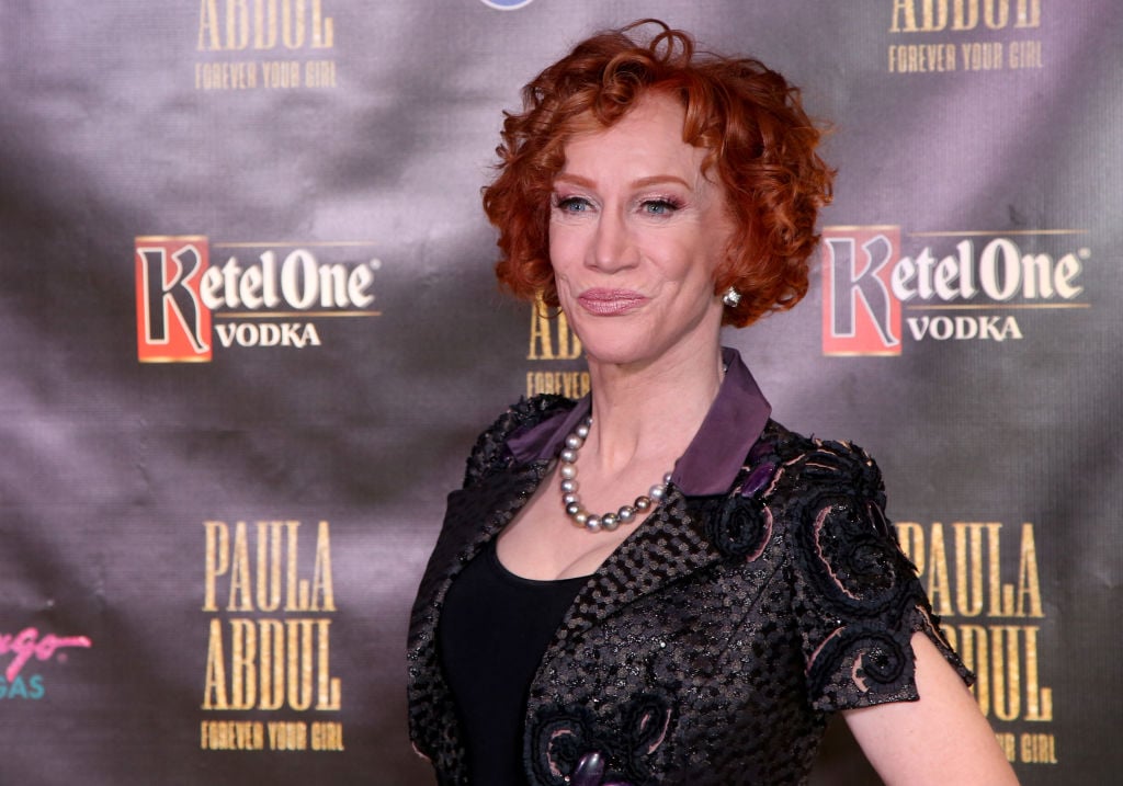 Kathy Griffin smiling in front of a dark background
