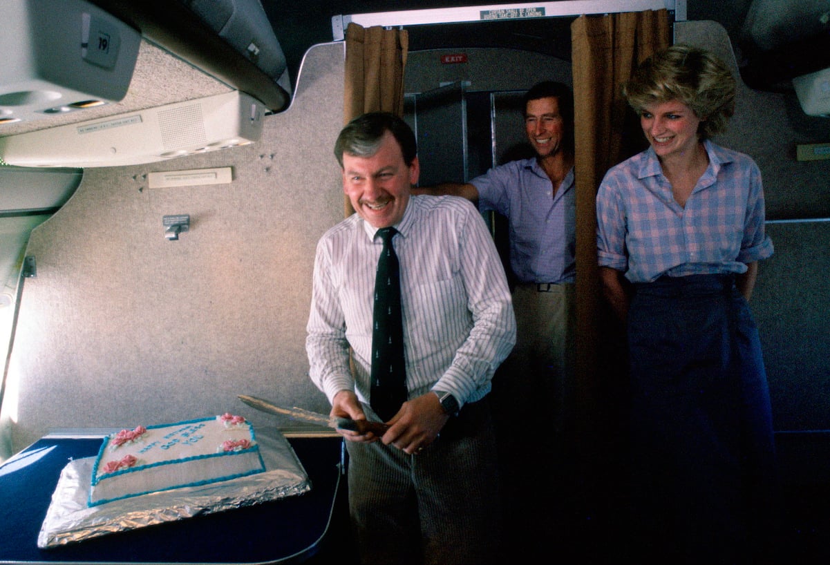 Ken Stronach cuts his birthday cake while Prince Charles and Princess Diana watch