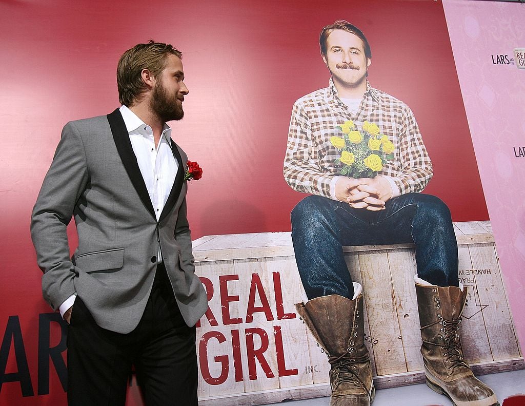 Ryan Gosling turned to the side, looking at a photo of his character from 'Lars and the Real Girl'