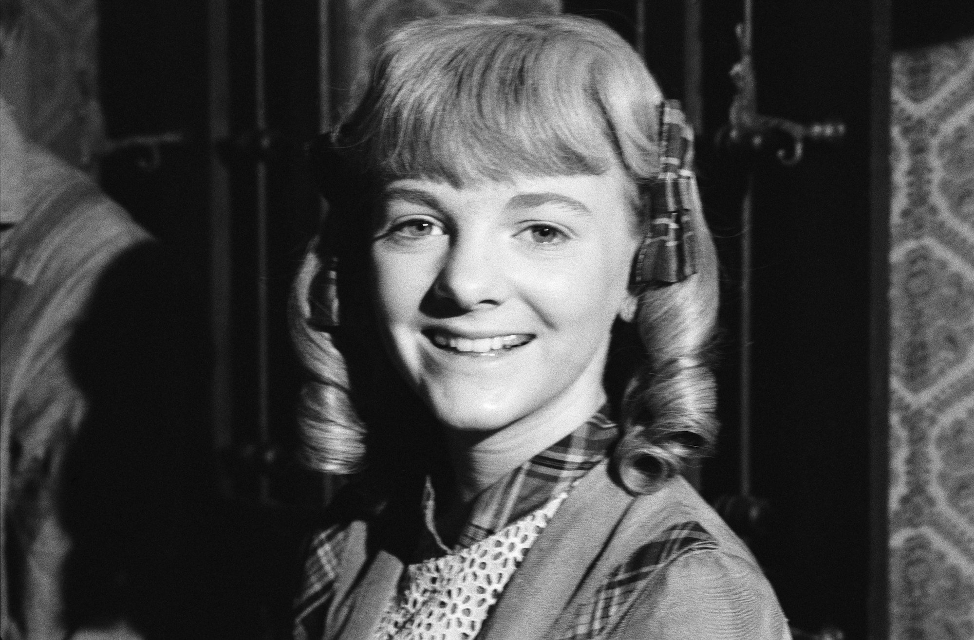 (L-R) Alison Arngrim as Nellie Oleson smiling, in black and white