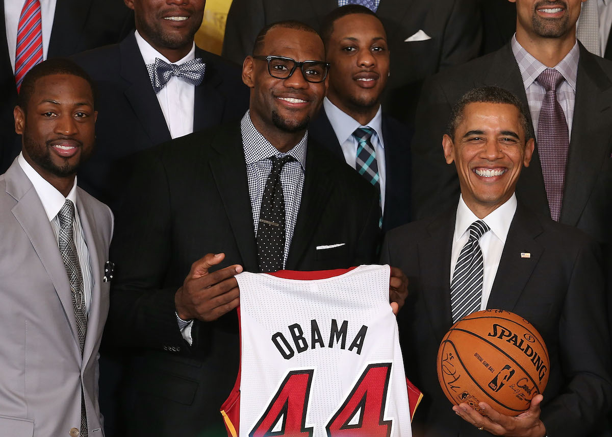 U.S. President Barack Obama (R) stands with Miami Heat players, including Dwyane Wade (L), LeBron James (2nd-L), and Mario Chalmers (2nd-R) during an event to honor the NBA champion Miami Heat in the East Room at the White House on January 28, 2013 in Washington, DC | Mark Wilson/Getty Images