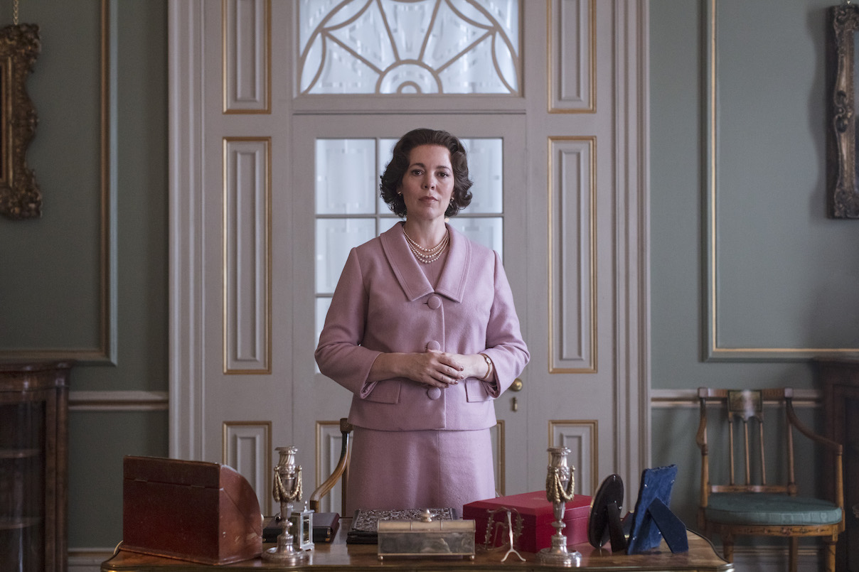 Olivia Colman stands behind a desk as Queen Elizabeth II in 'The Crown' Season 3