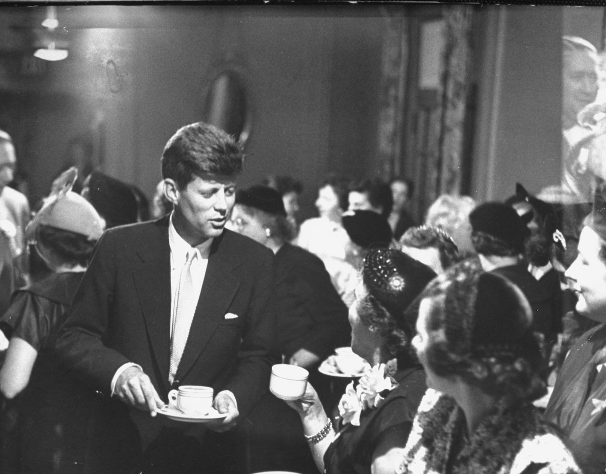 John Kennedy chatting with women at a political tea during his campaign