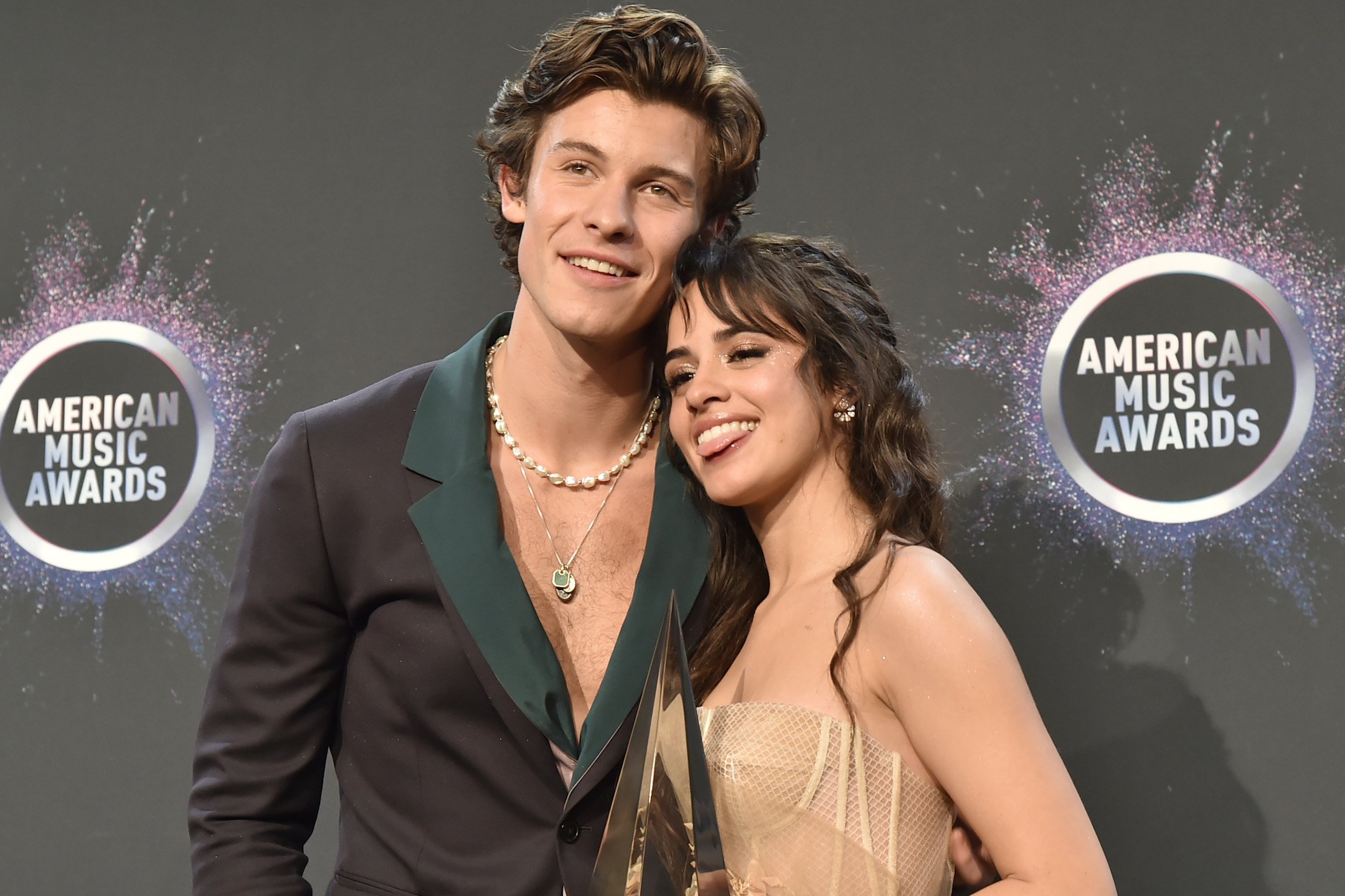 Shawn Mendes and Camila Cabello posing together in front of gray background
