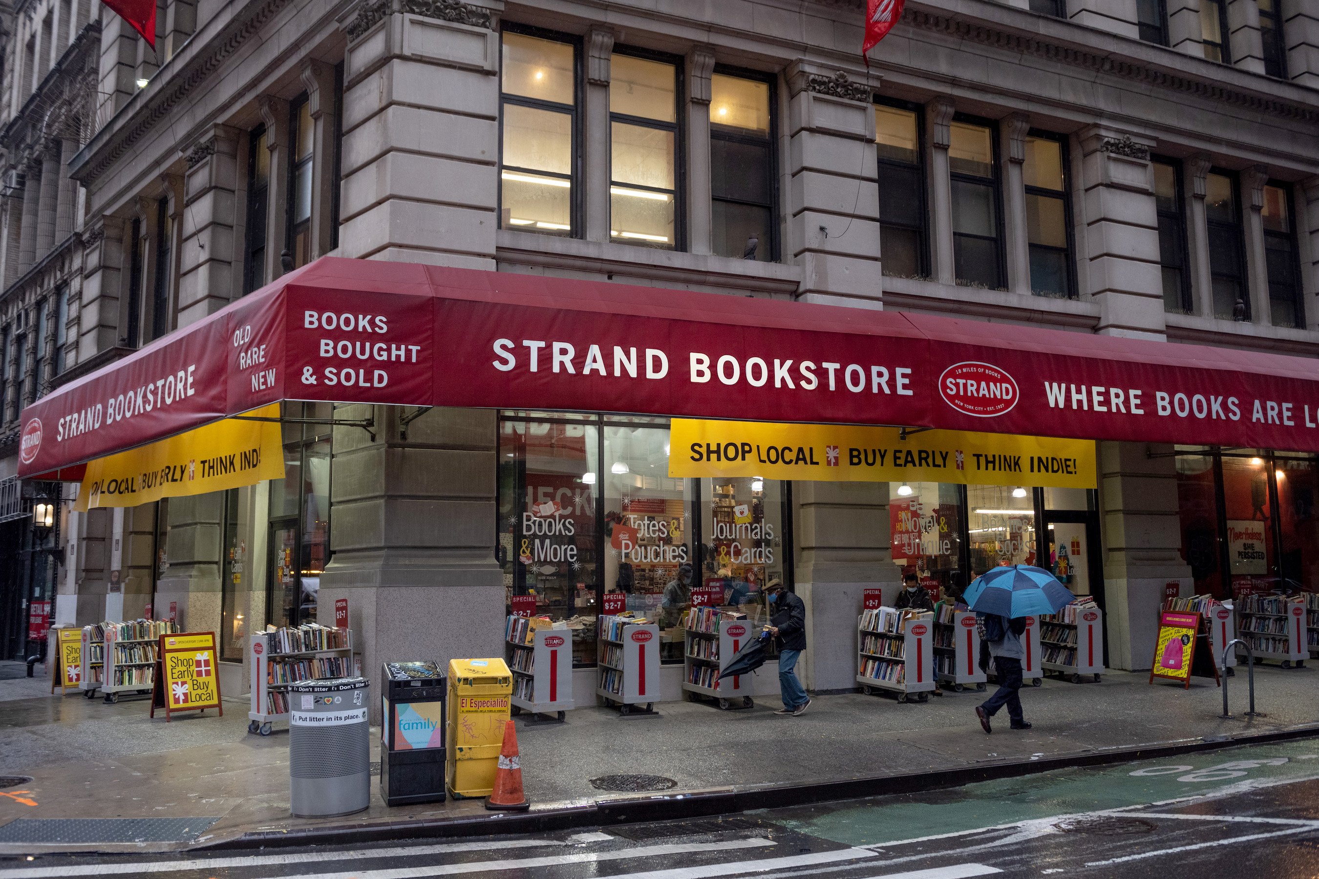 People wearing masks walk past the Strand bookstore