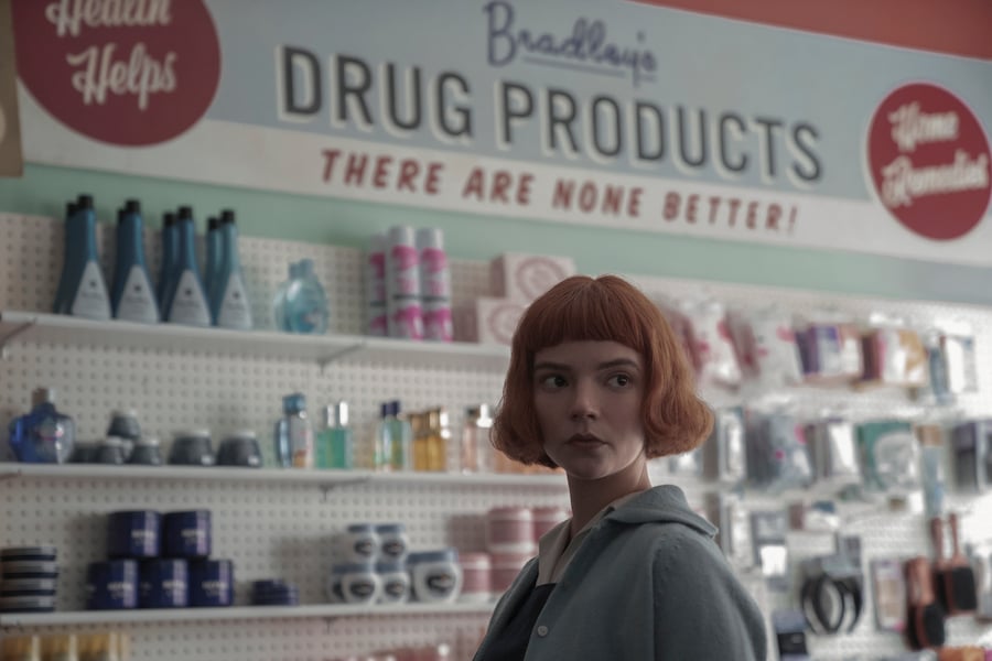 Anya Taylor-Joy stands in a pharmacy as Beth Harmon on 'The Queen's Gambit'